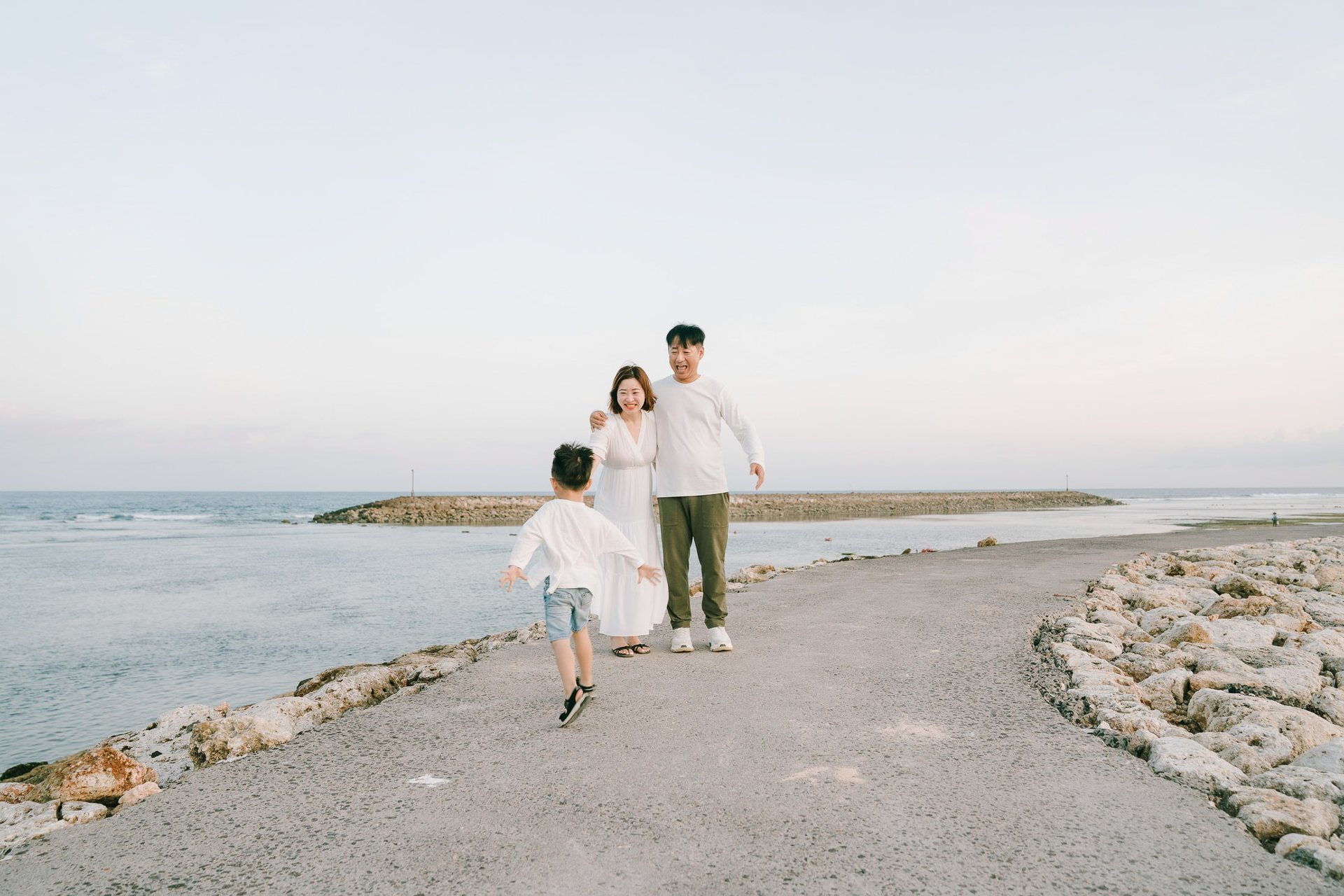 Candid family moment captured during a beach photography session at The Apurva Kempinski Bali.
