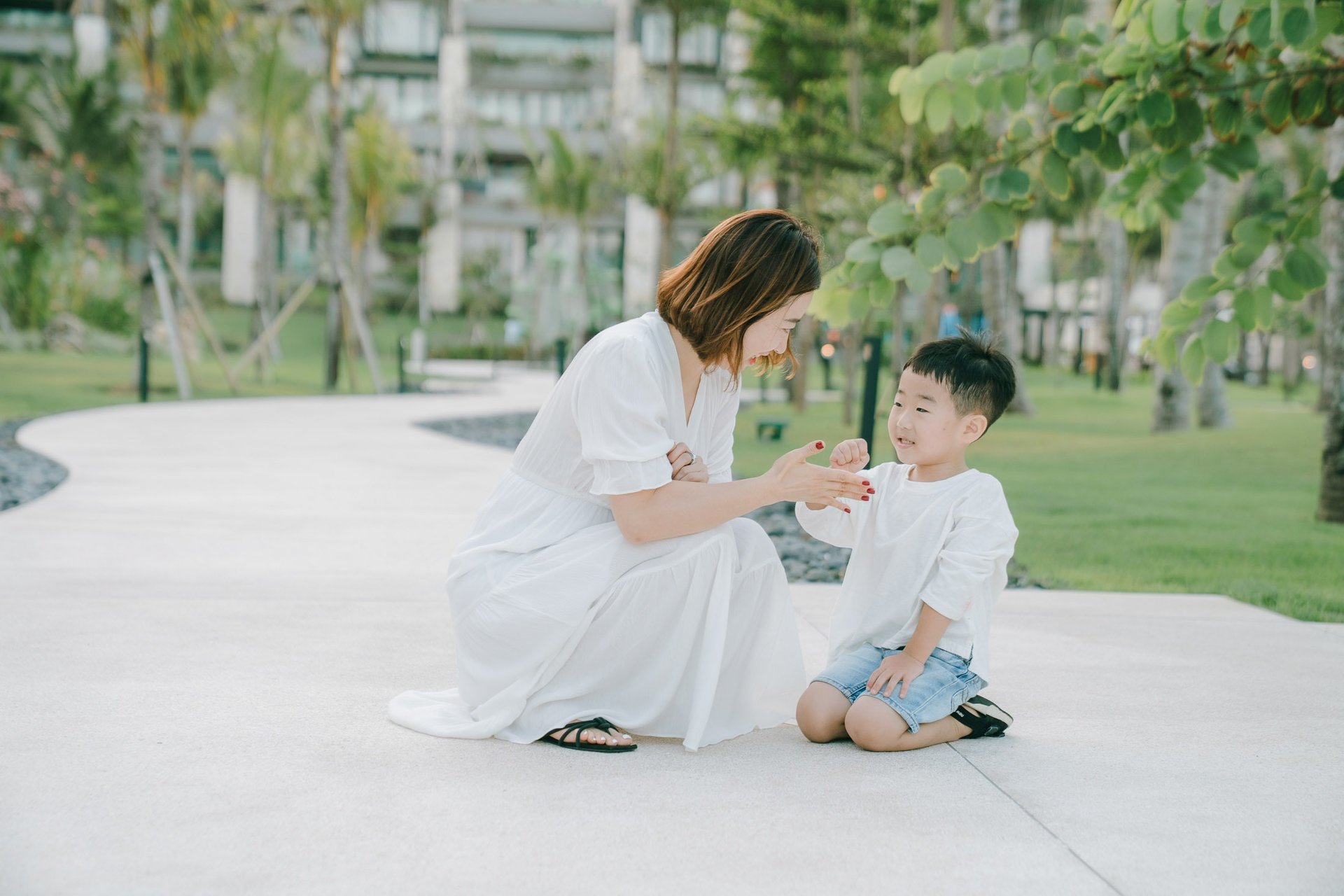 Mother and child interaction captured during a family photography session at The Apurva Kempinski Bali garden area.