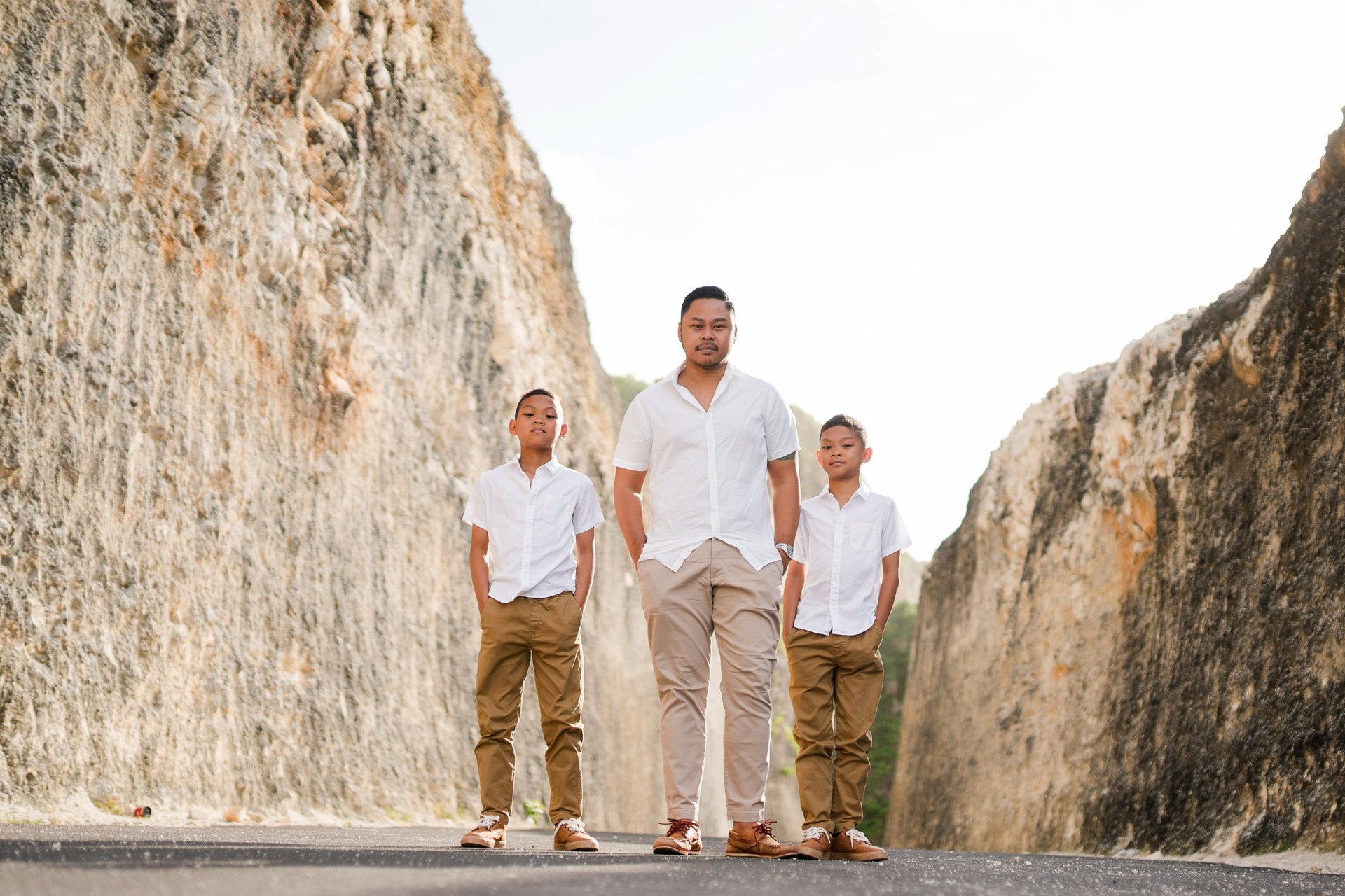 Family portrait of Ayunda family standing along the limestone cliffs at Melasti Beach Bali.