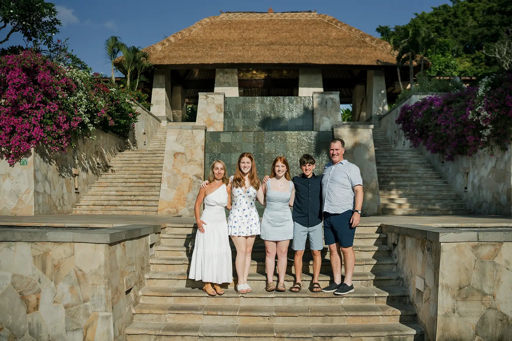 Family portrait at the iconic entrance of AYANA Resort Bali during a luxury family photography session