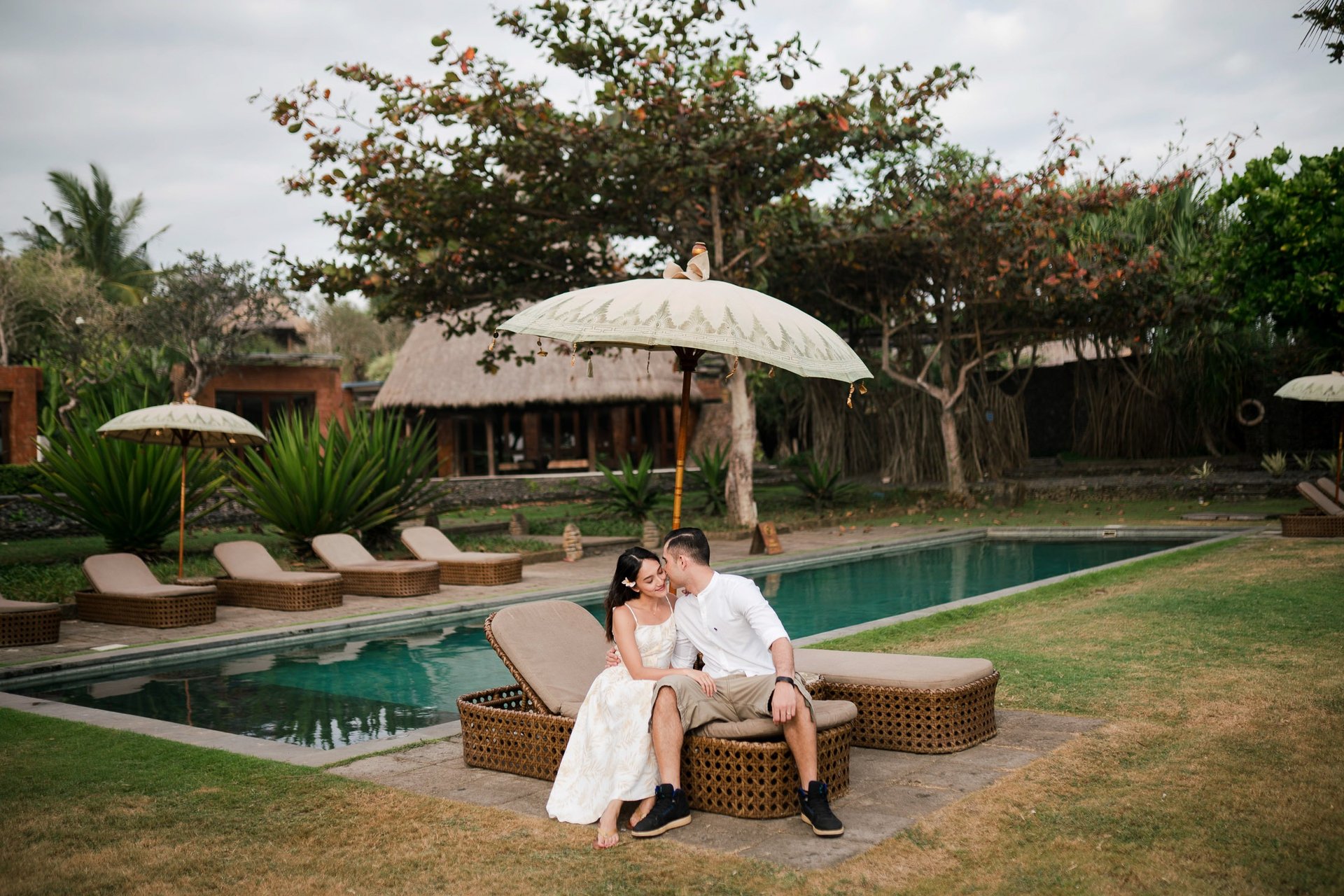 Romantic couple seated by the pool at Waka Gangga luxury resort in Tabanan Bali