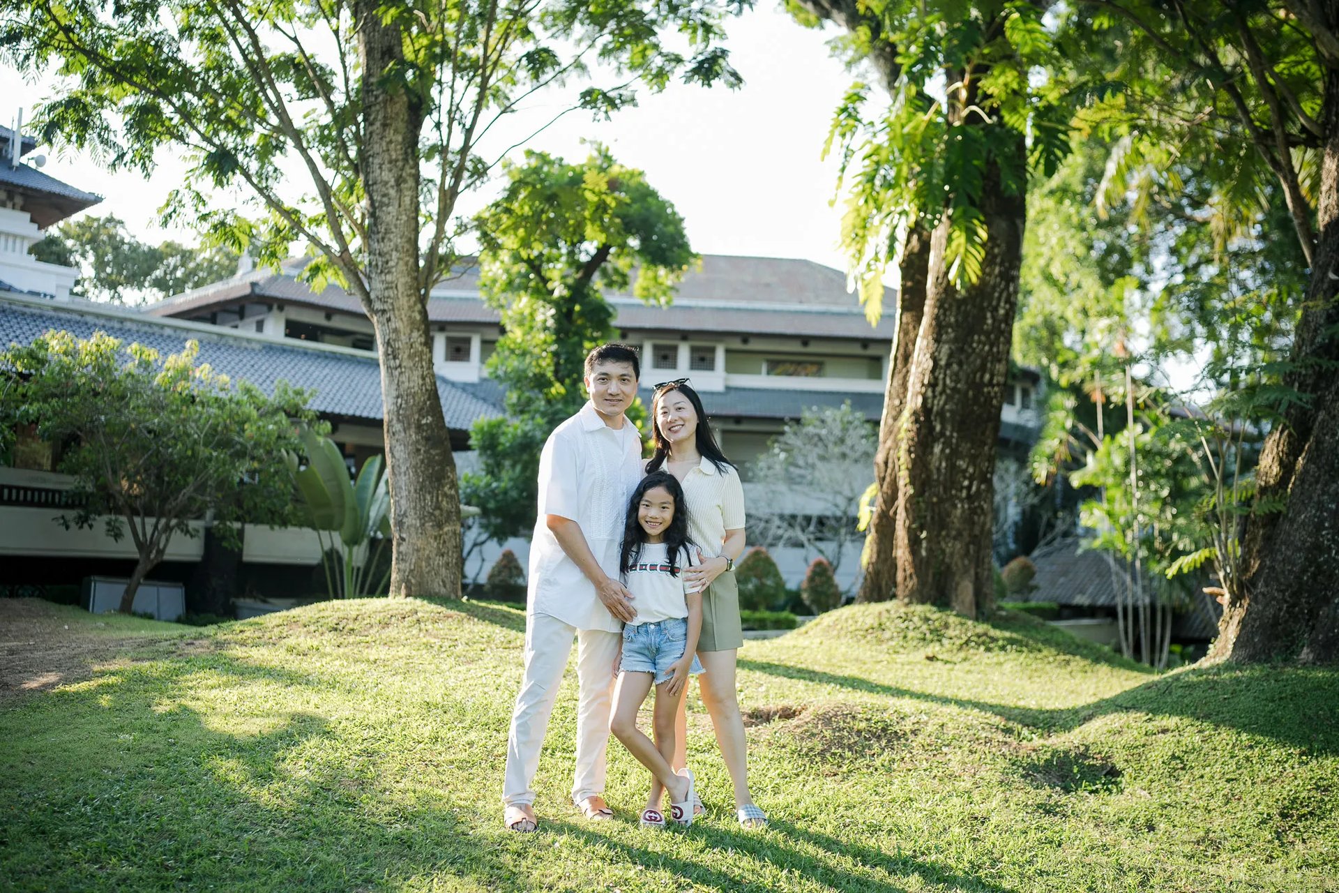 Family standing together on the resort lawn during a family photography session at InterContinental Bali Resort