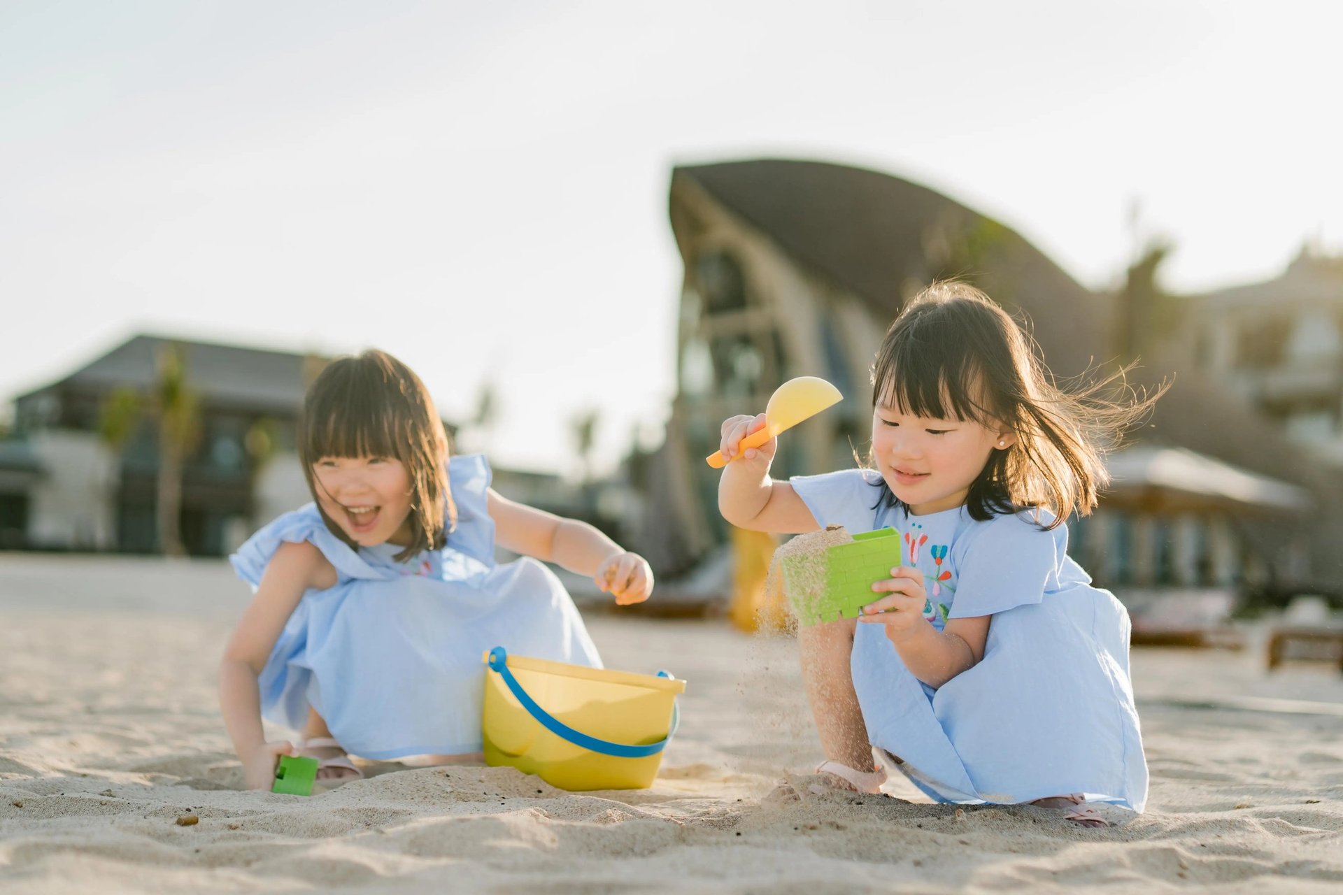 Child playing in the sand during a family photography session at The Apurva Kempinski Bali beach