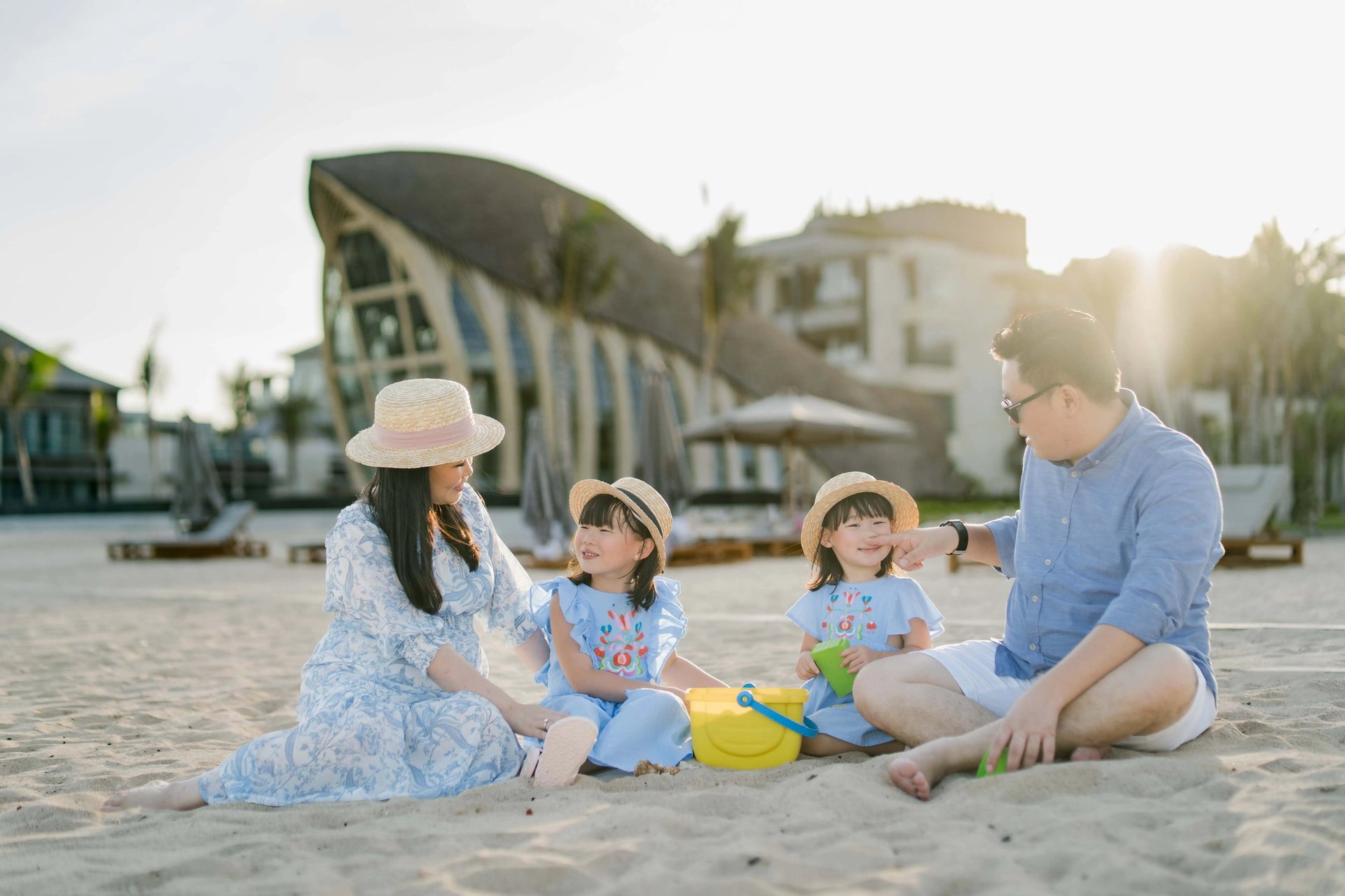 Family playing together on the beach at The Apurva Kempinski Bali.