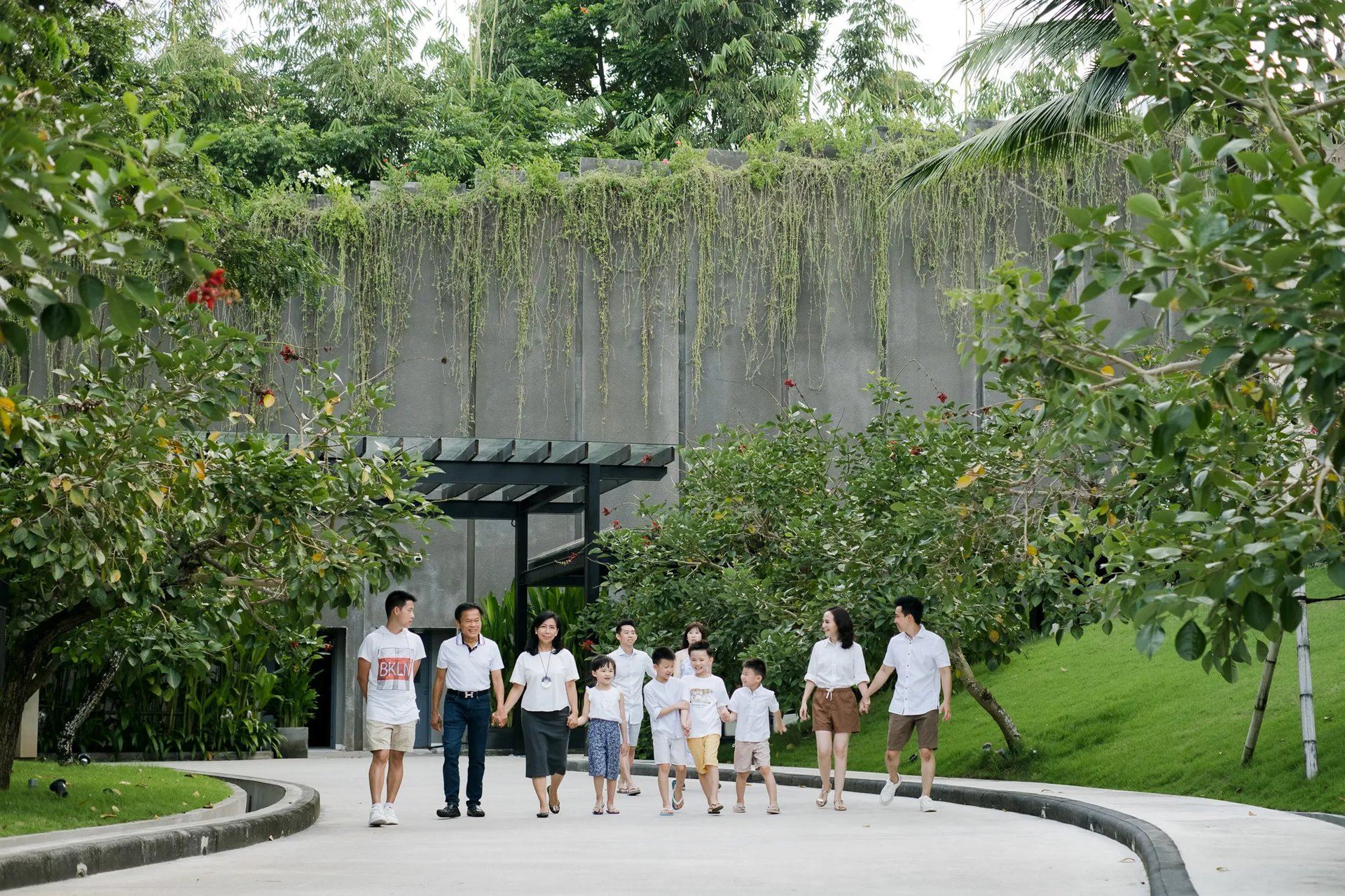 Multi-generation family walking through the tropical garden pathways at The Apurva Kempinski Bali