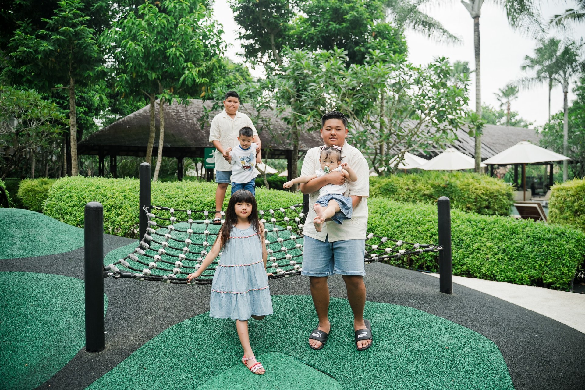 children playing in a tropical playground during a family photography session at Movenpick Jimbaran Bali