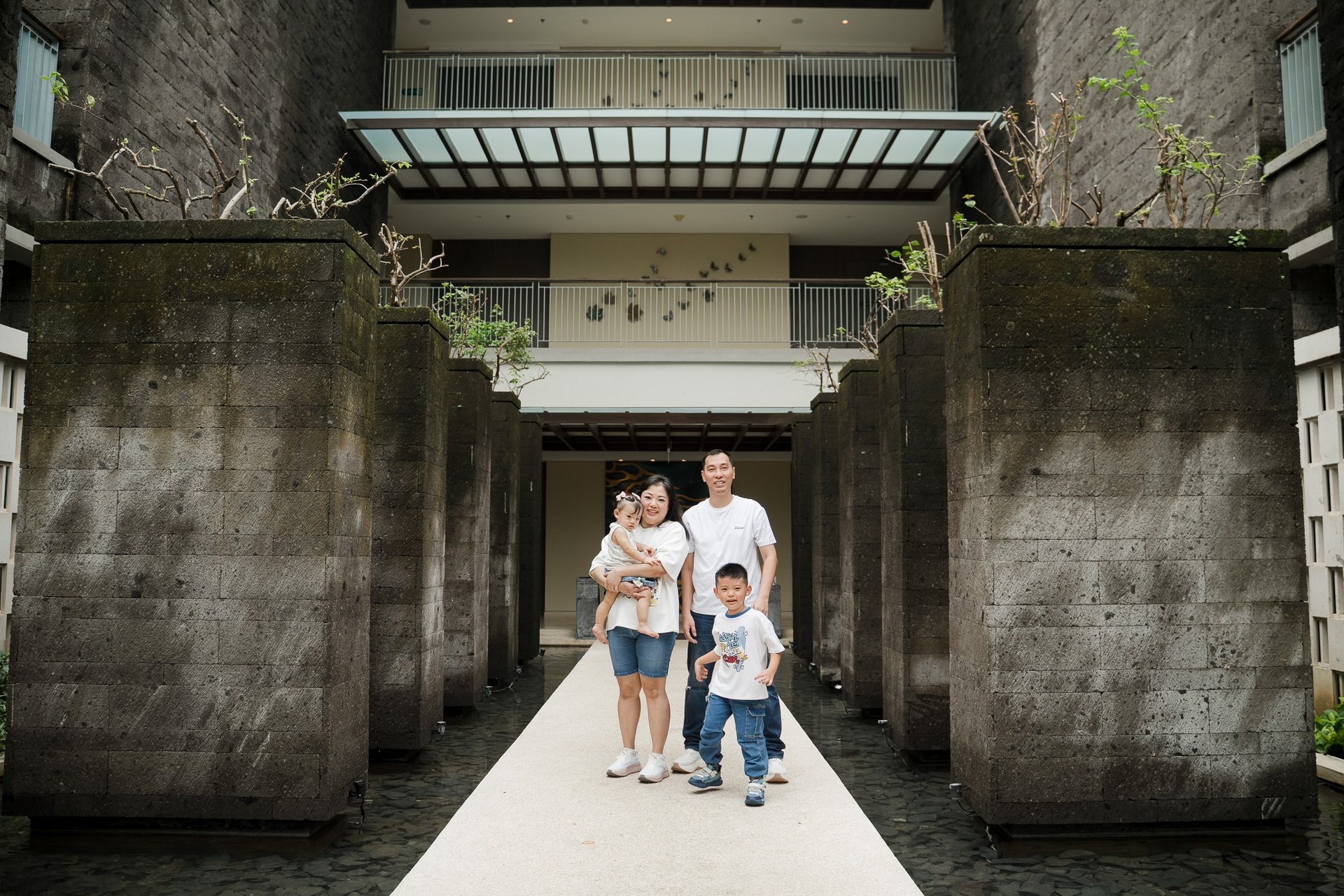 family walking through architectural walkway at Movenpick Jimbaran Bali during a lifestyle photography session