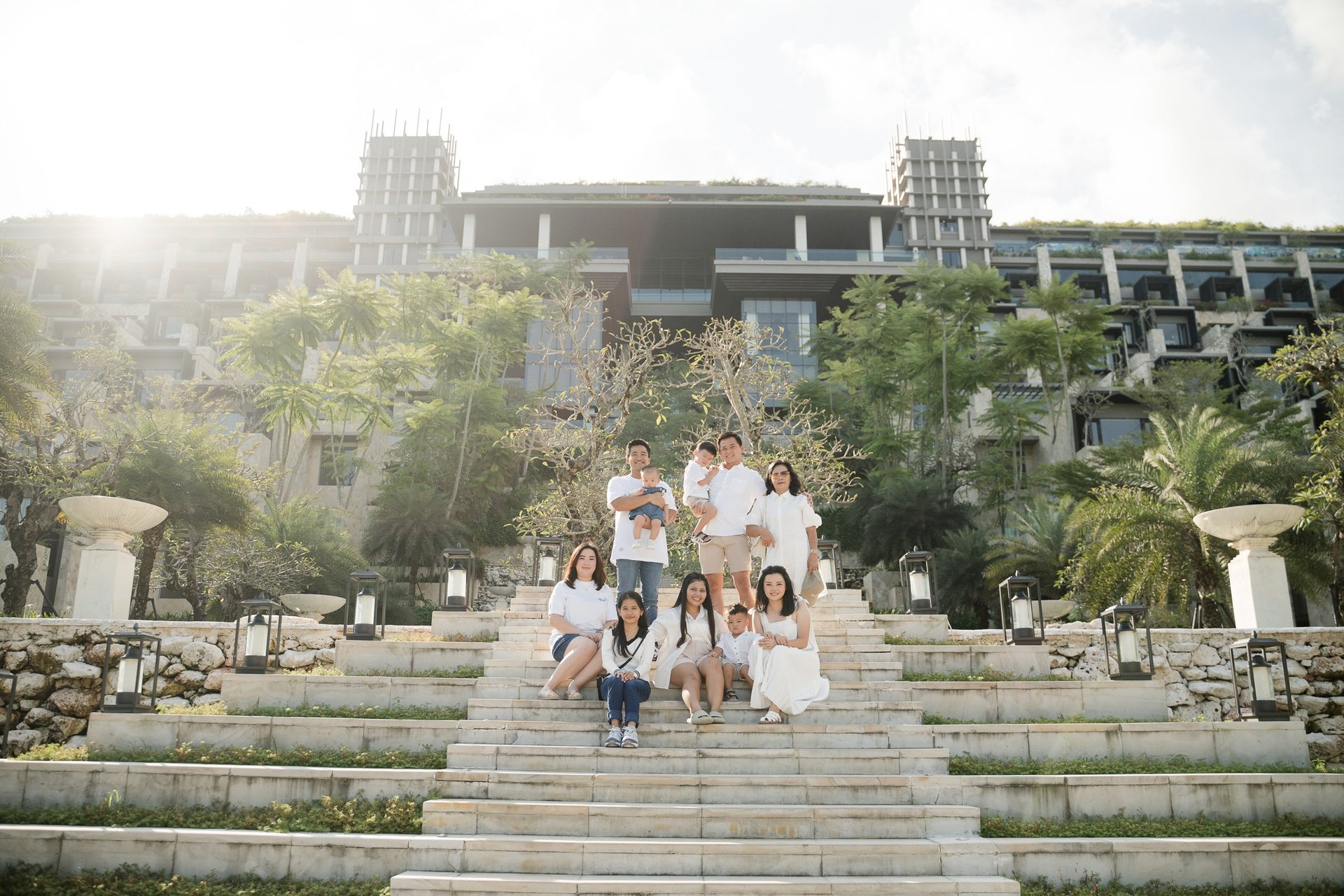 Large family walking down the iconic staircase at The Apurva Kempinski Nusa Dua during a Bali family photography session