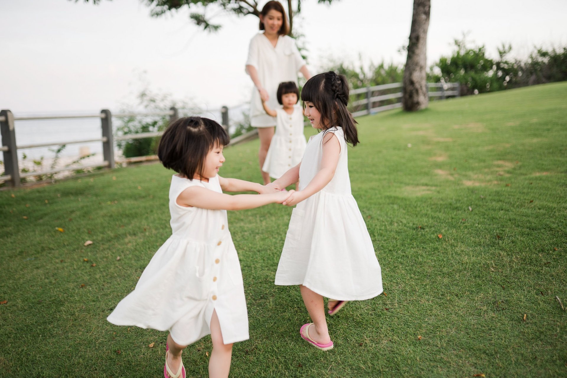 Father and children playing with sand on the beach at The Mulia Nusa Dua Bali during a relaxed family photo session