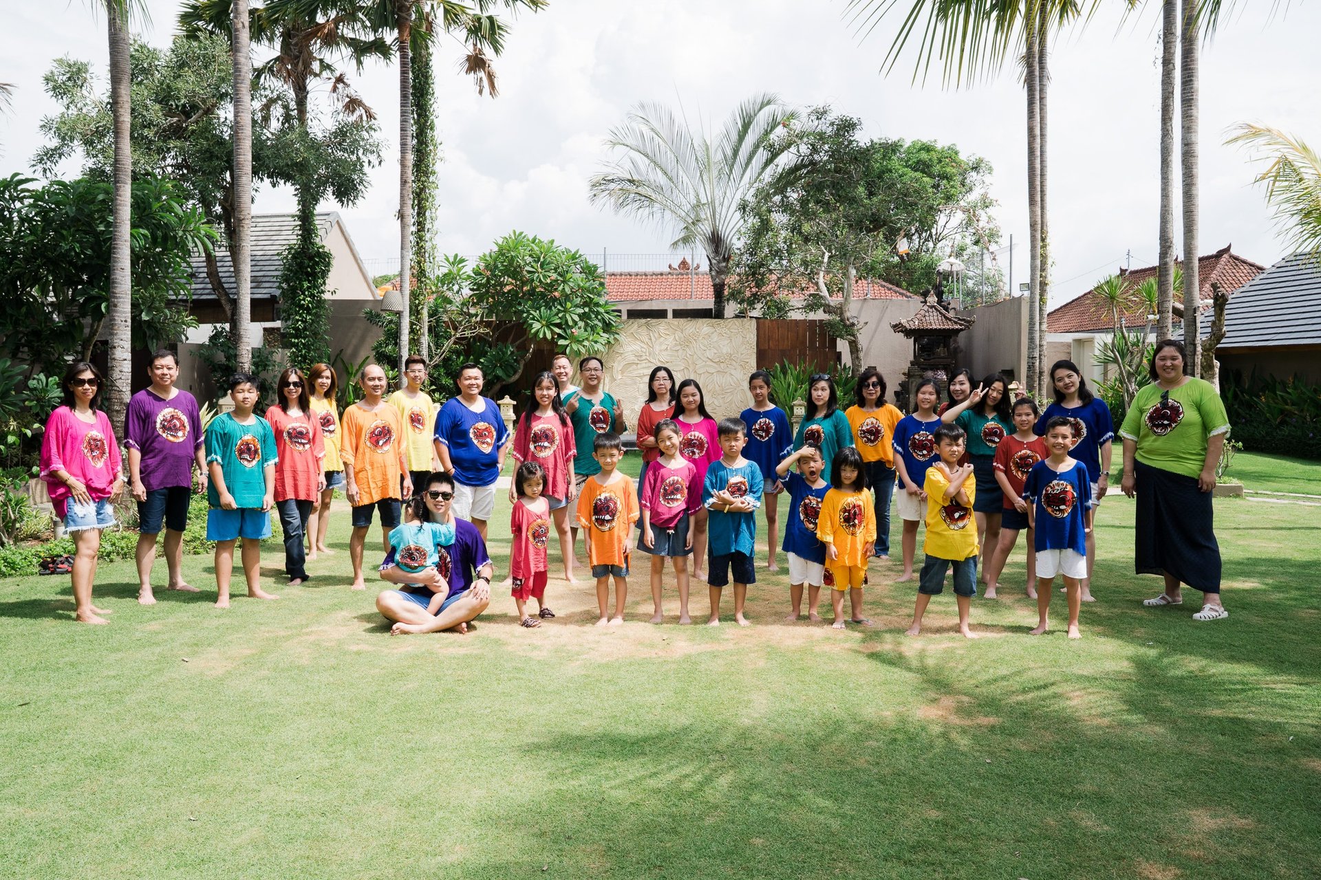 Extended family group portrait at Lumbini Villas Jimbaran Bali with multiple generations in a tropical garden setting