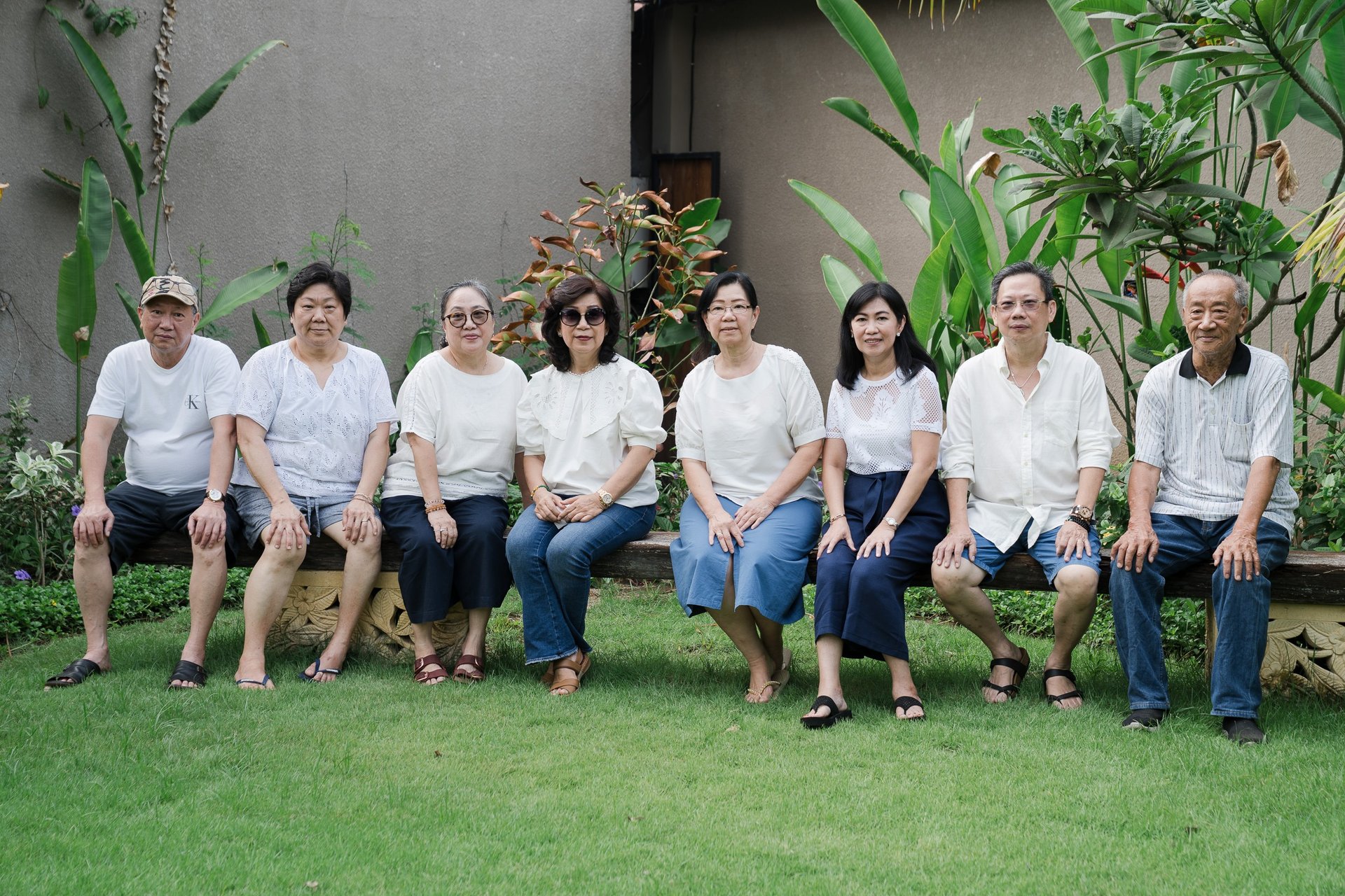 Multigenerational family seated in a row during extended family photography at Lumbini Villas Jimbaran Bali