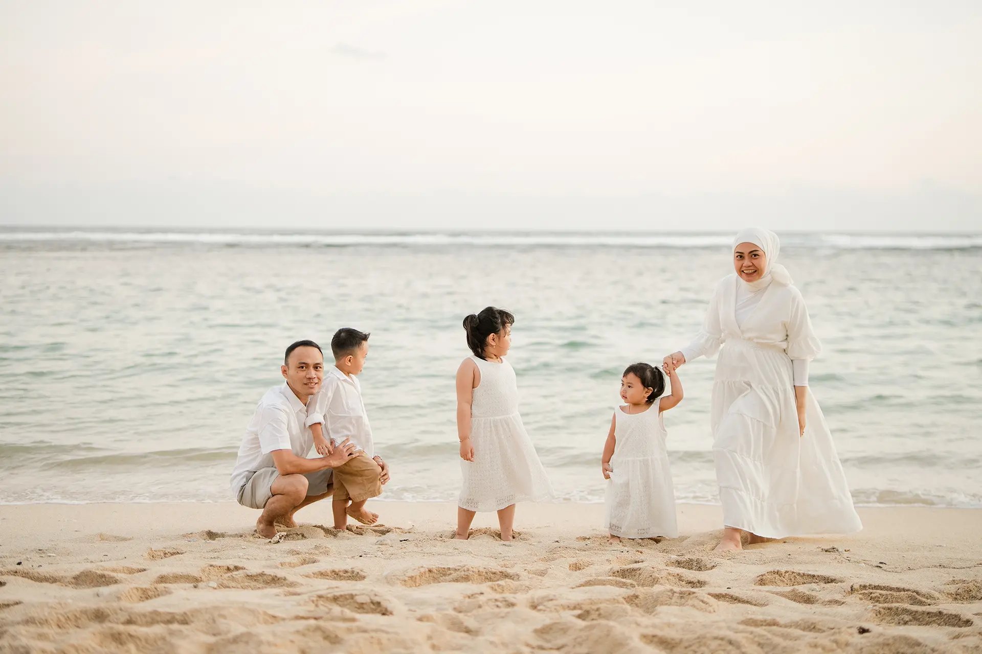 Quiet family moment by the shoreline during Ilham family photography session at Melasti Beach Bali