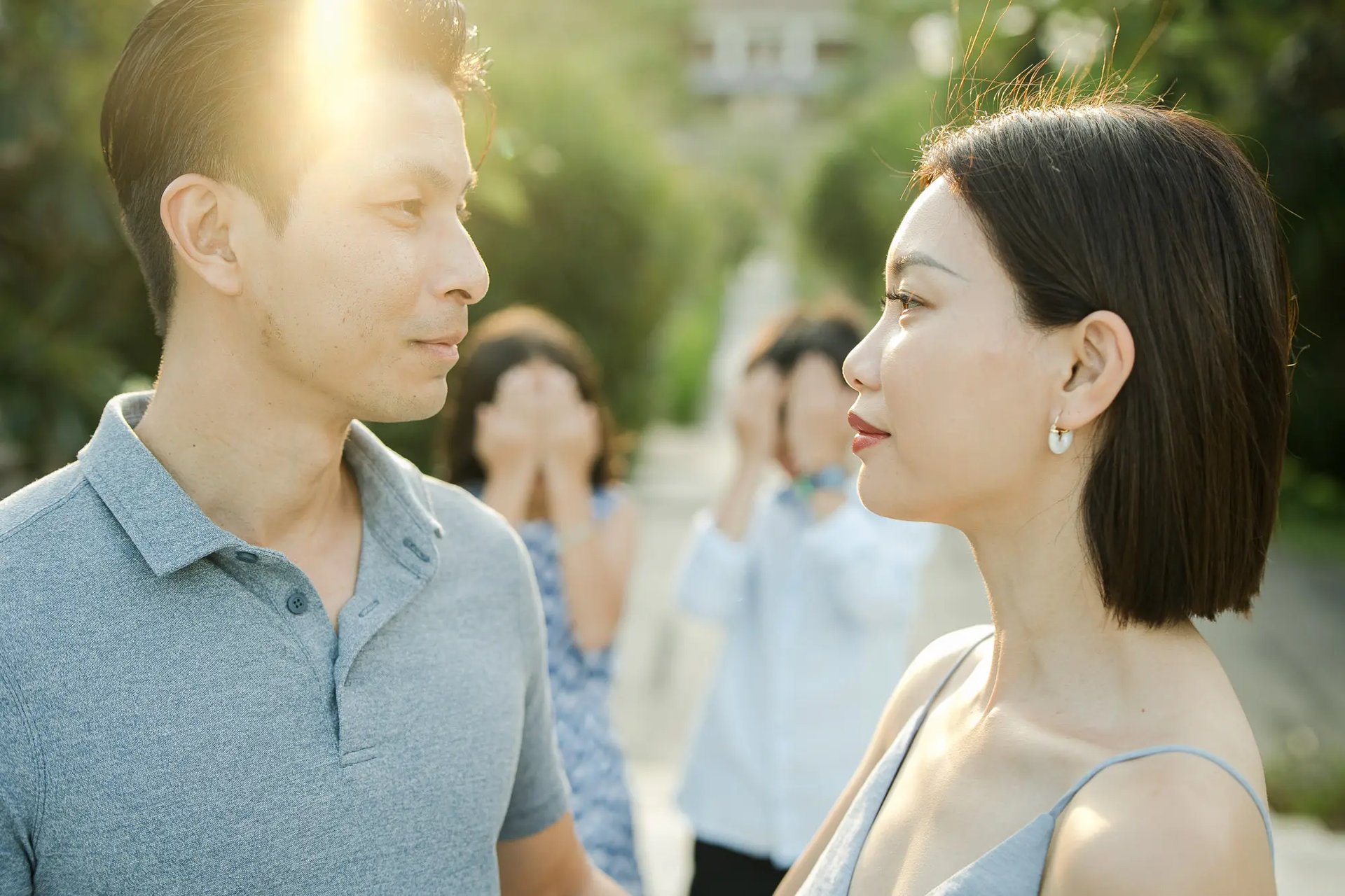 Couple sharing a romantic moment in a tropical garden during a luxury family photography session at The Ritz-Carlton Bali.