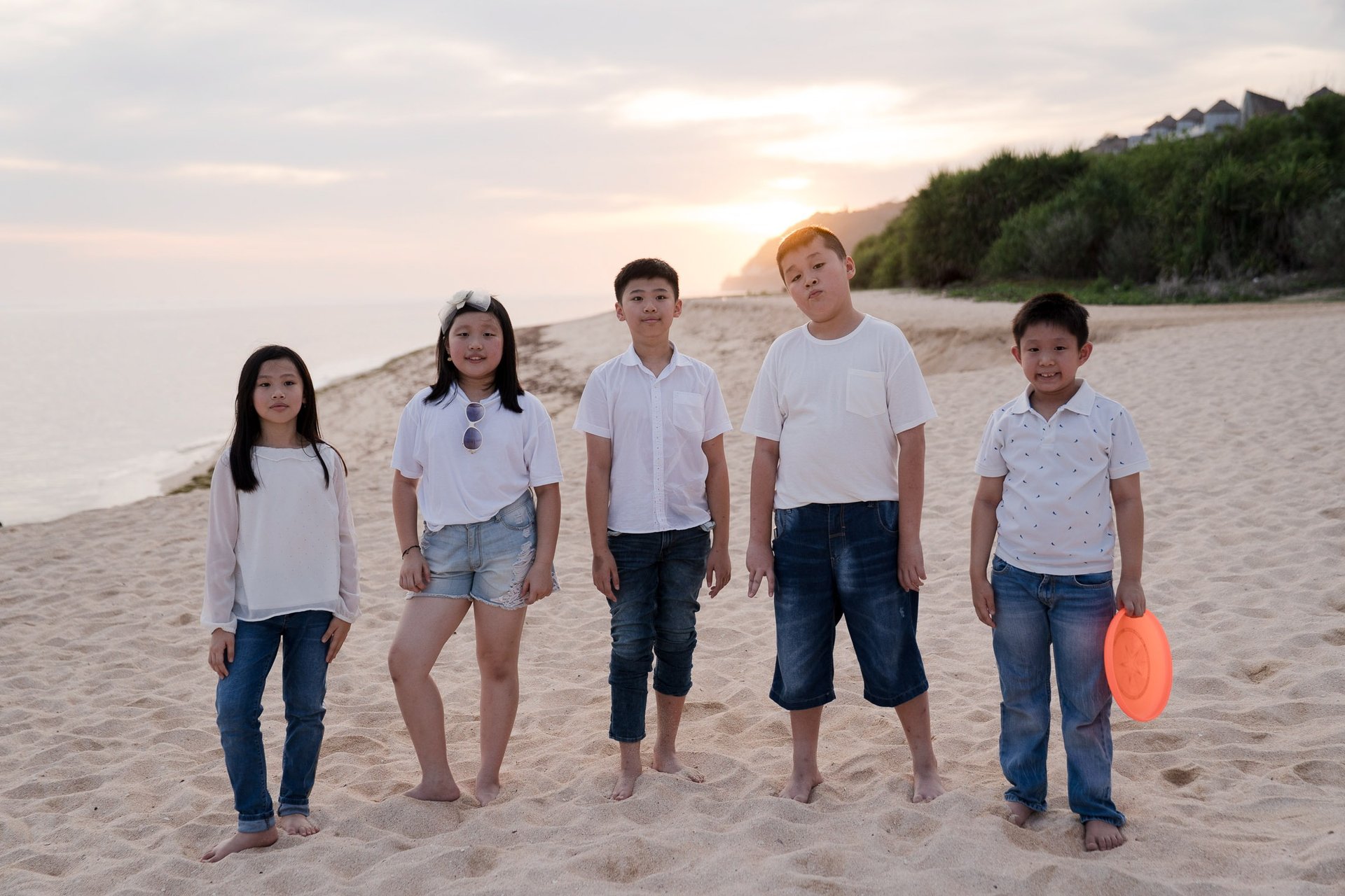 Extended family standing together along the beach at The Ritz-Carlton Bali in Nusa Dua