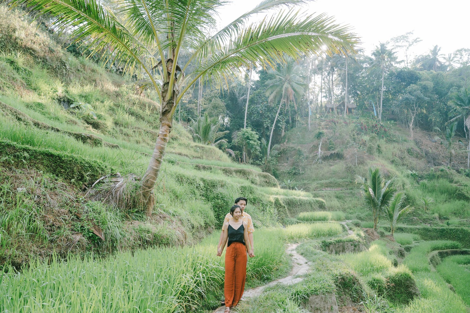 Intimate couple in a wide rice terrace landscape during a sunrise photography session at Tegalalang Ubud Bali.