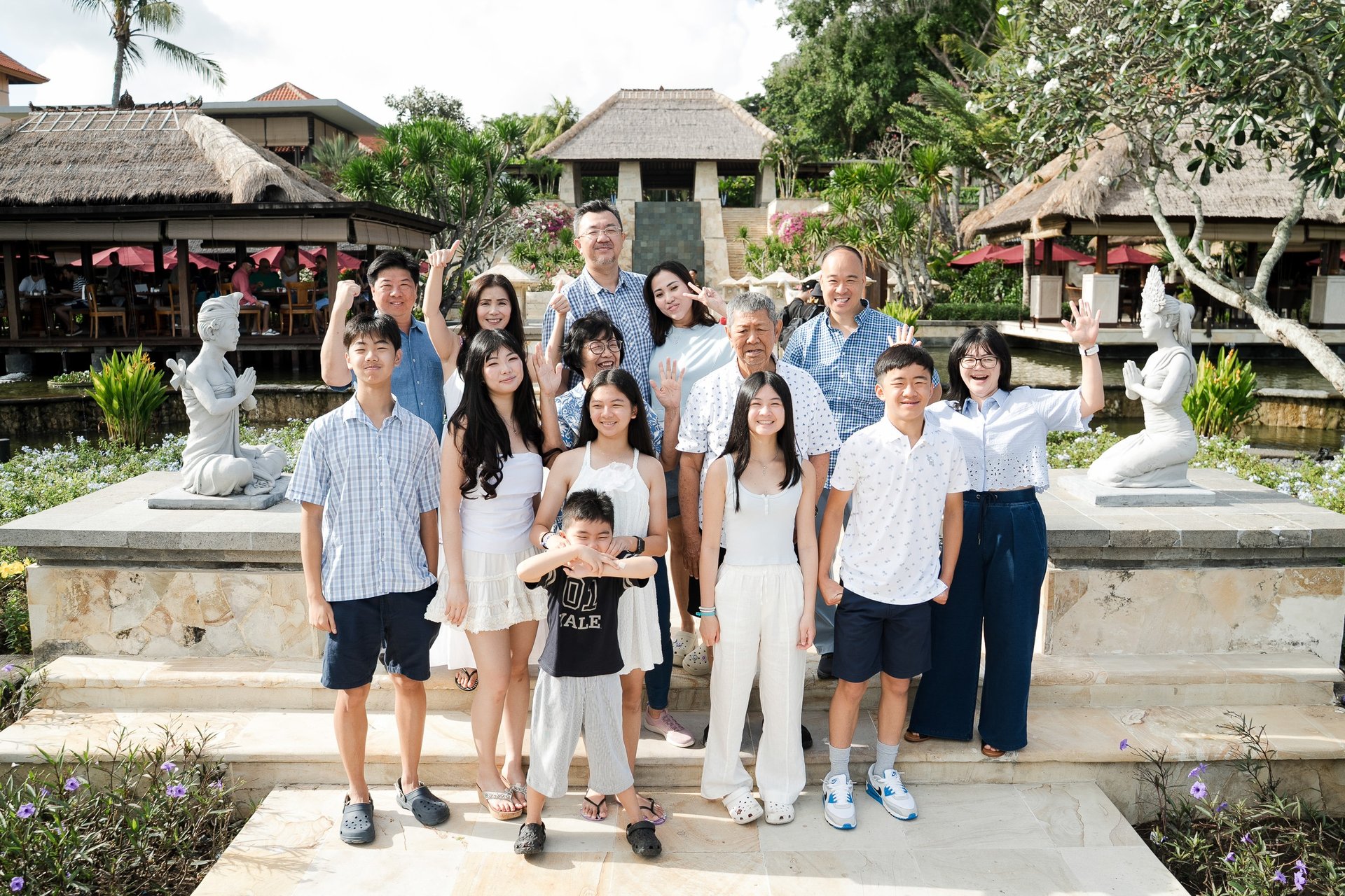 Large extended family portrait in a garden setting captured during a family photography session at Ayana Jimbaran Bali