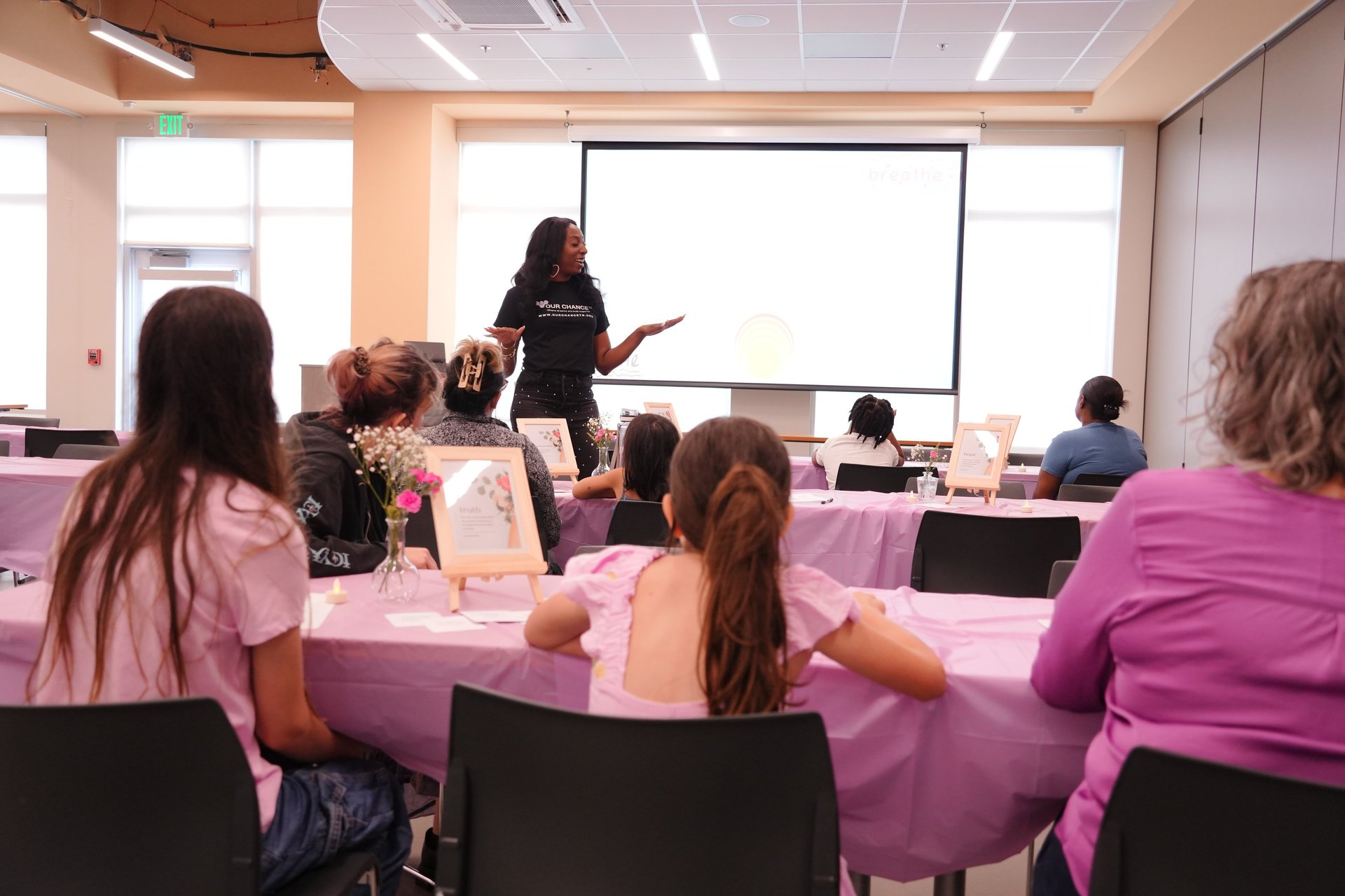 Ain leads an empowering workshop for women and girls at a community center event.