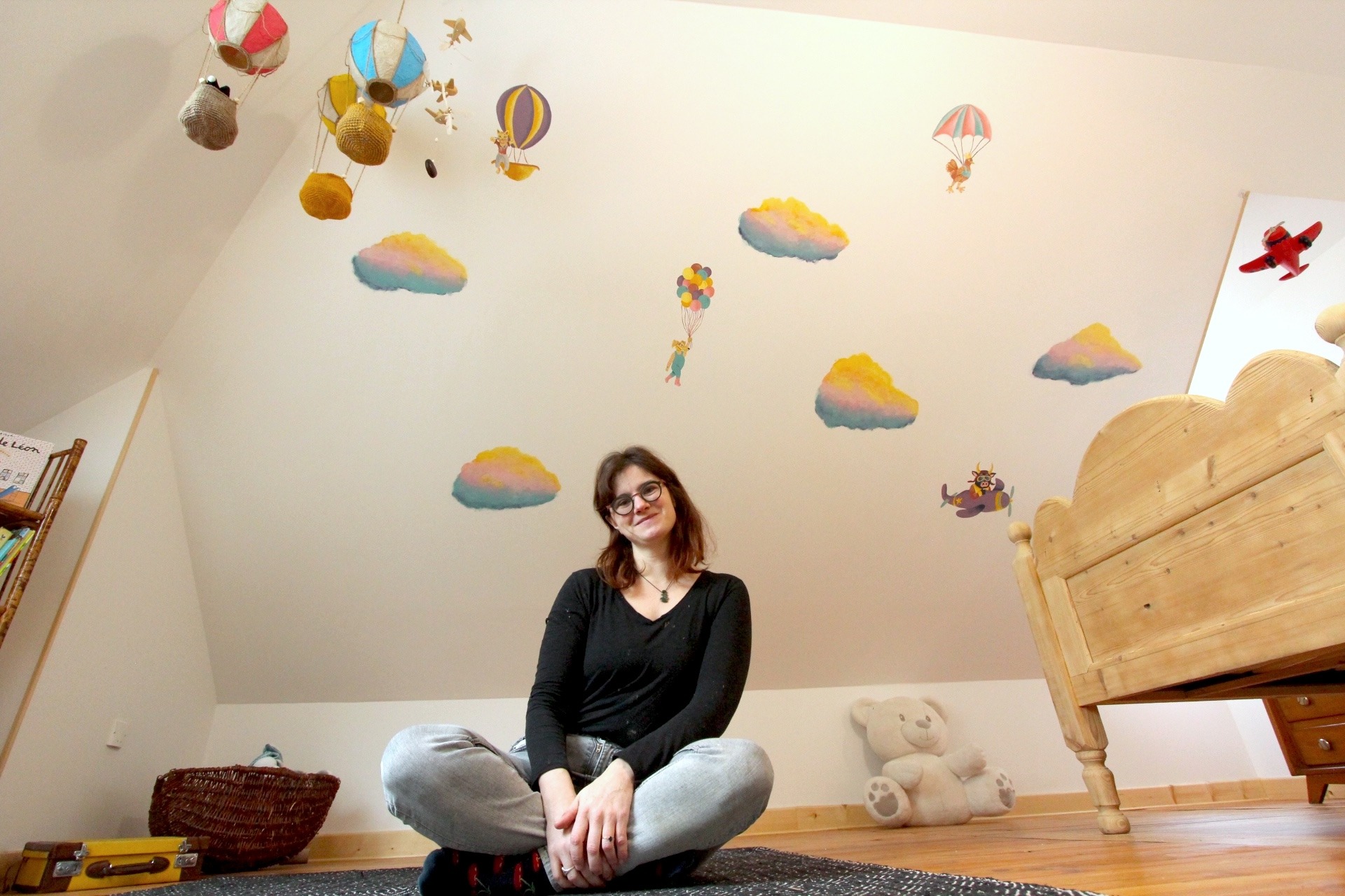 artiste Marie Hardy devant peinture murale en couleurs chambre enfant Aunay sur Odon Caen Normandie