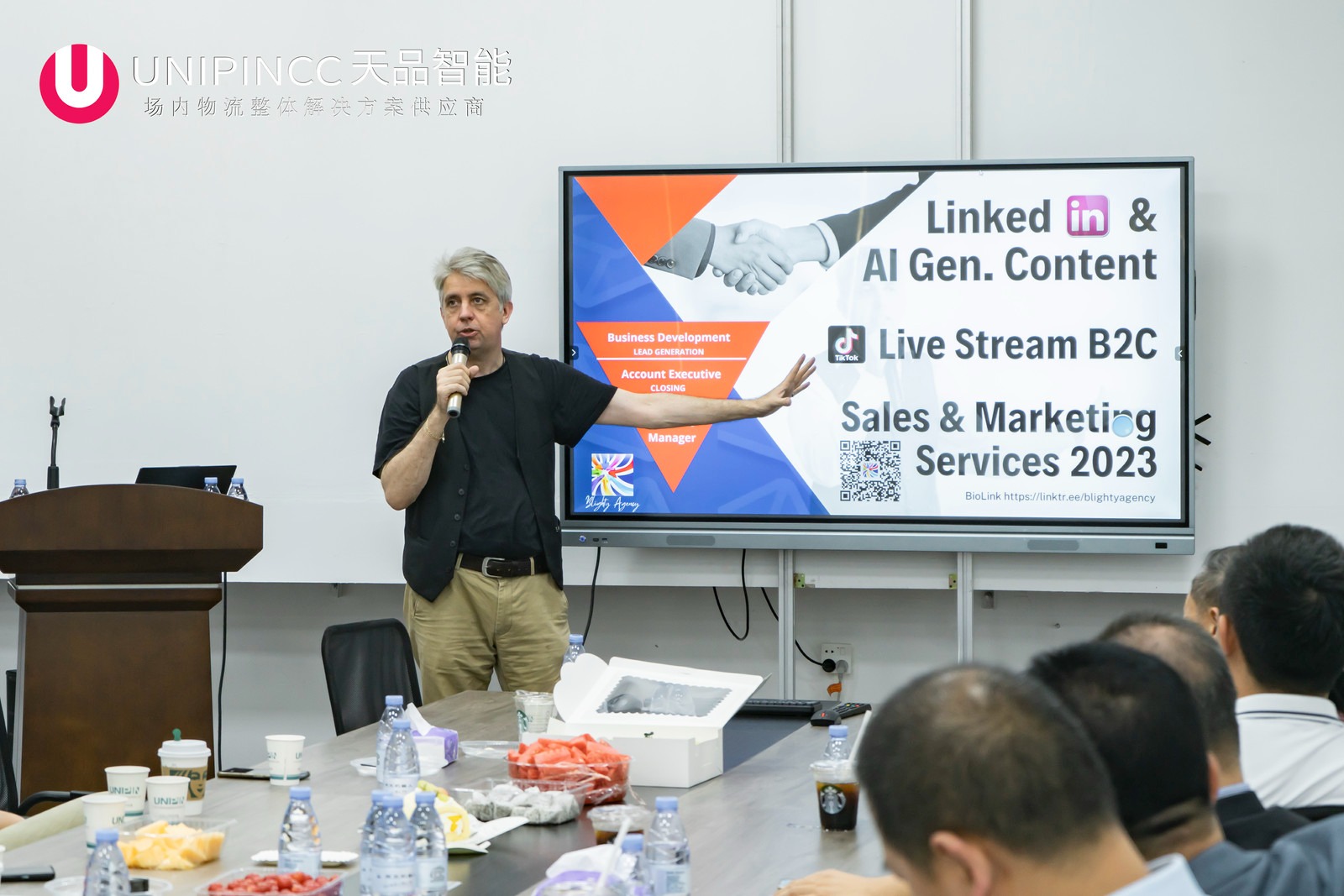 a man standing in front of a large screen
