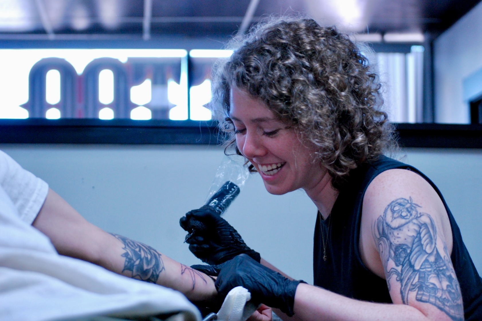a woman tattoo artist tattooing