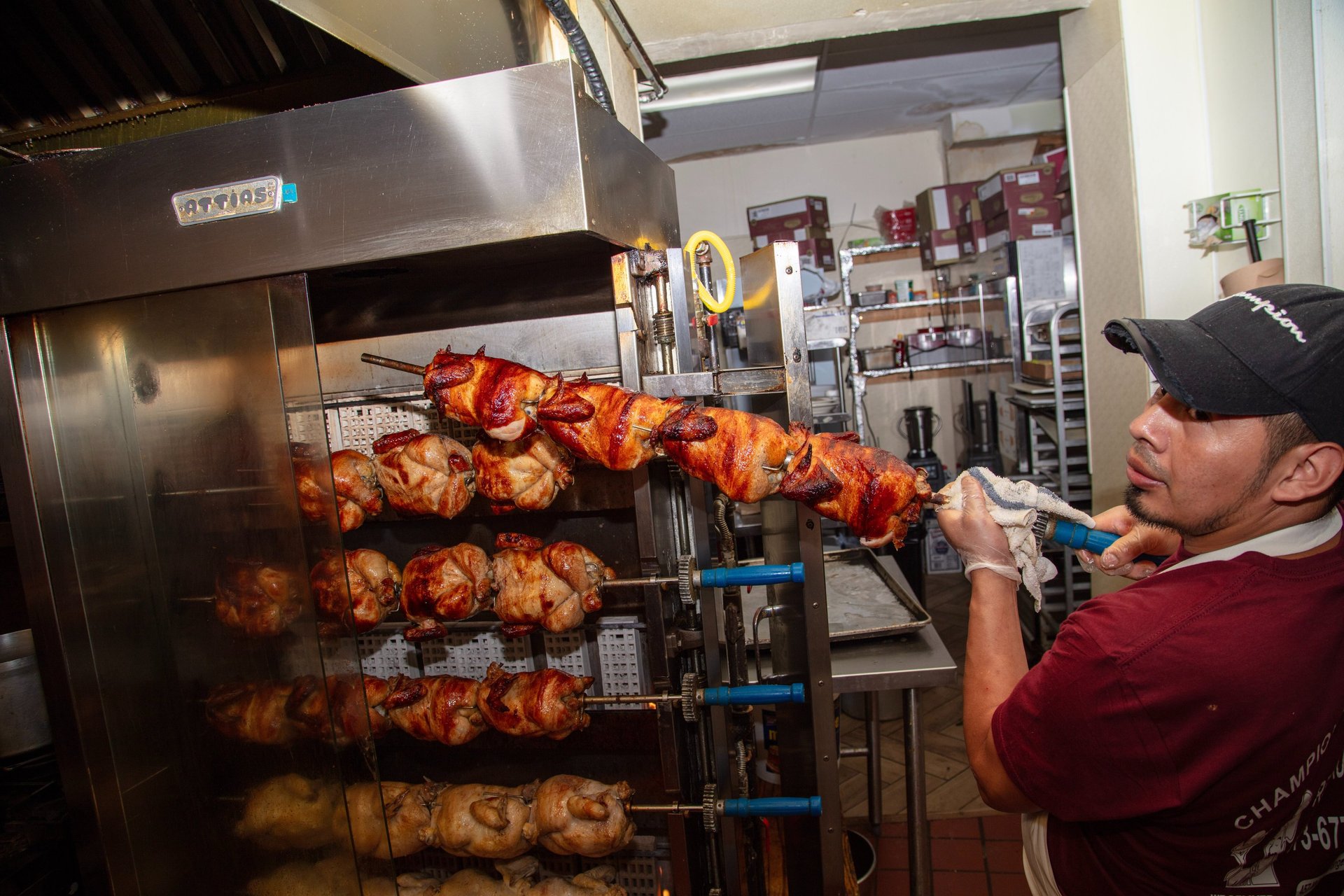 a man in a red shirt is holding a large rack with chicken