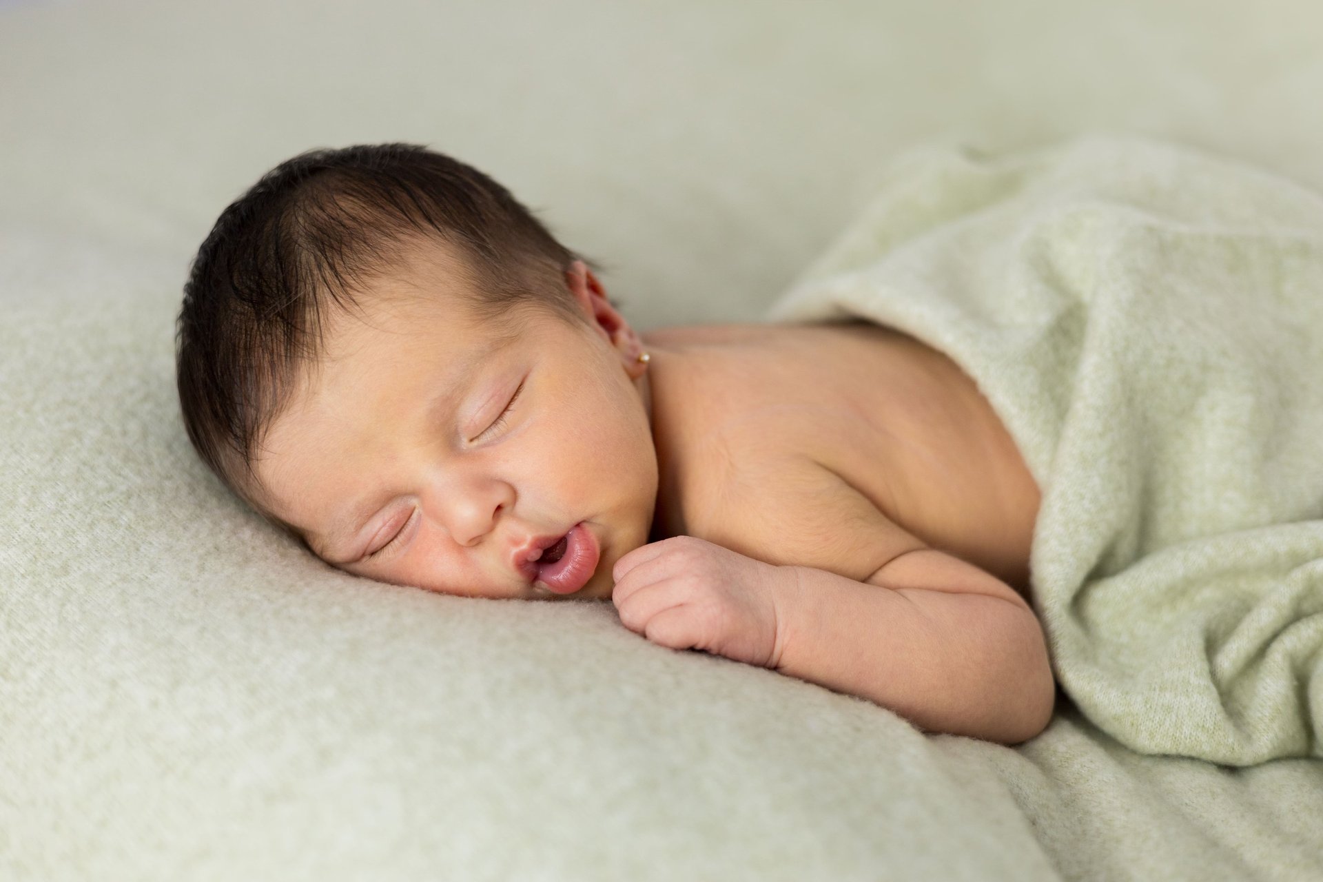 Sessió de fotos newborn a Girona amb una bebè recent nascuda dormint en estudi fotogràfic