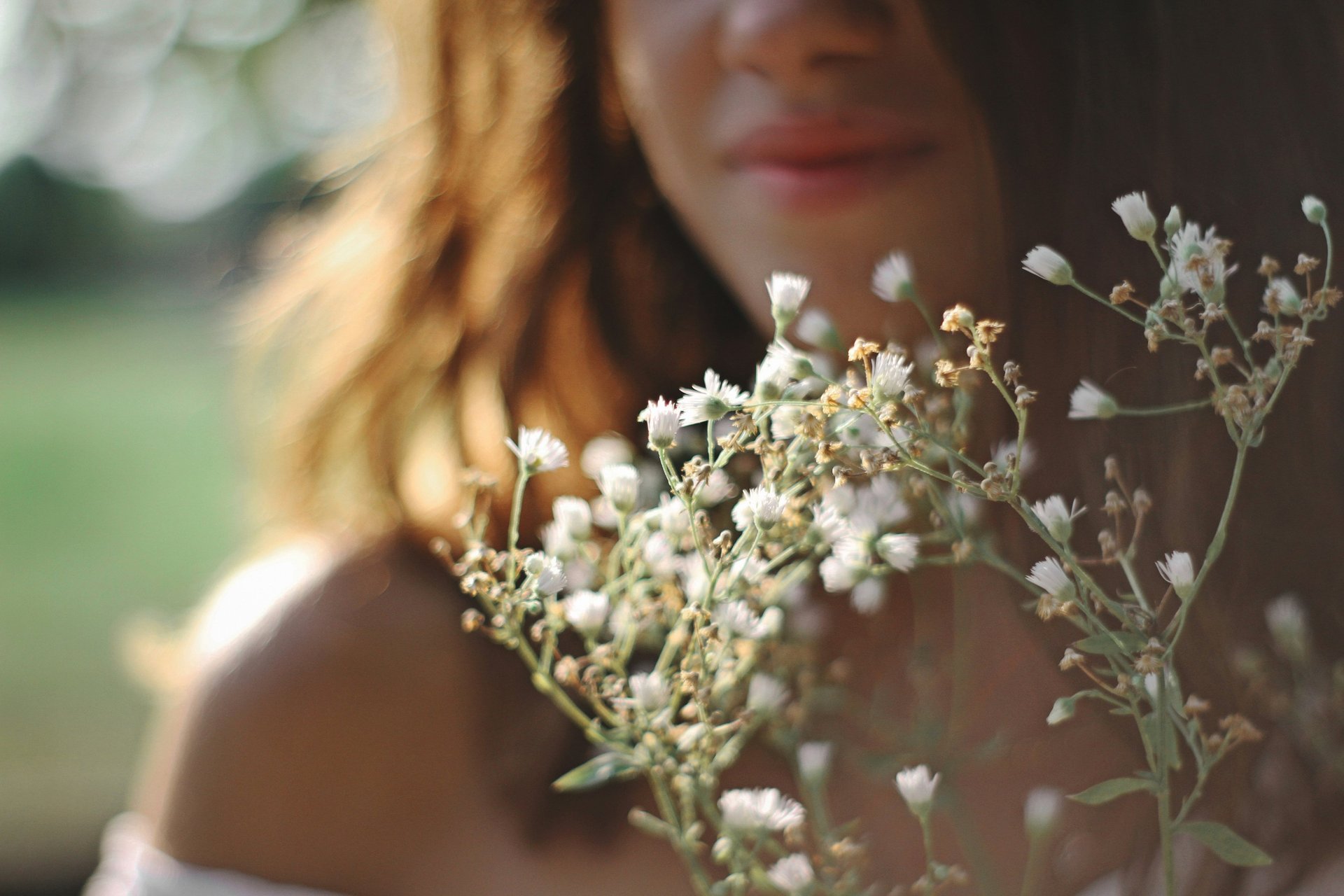 femme avec une robe blanche tenant un bouquet de fleurs