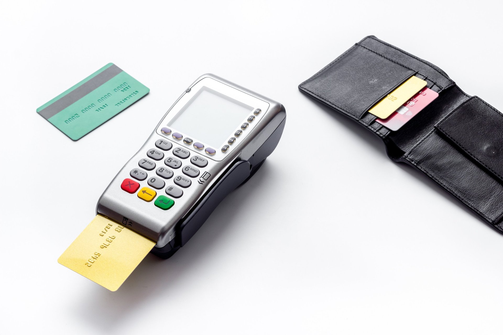 Terminal de paiement par carte bleue posé à côté de deux cartes bleues