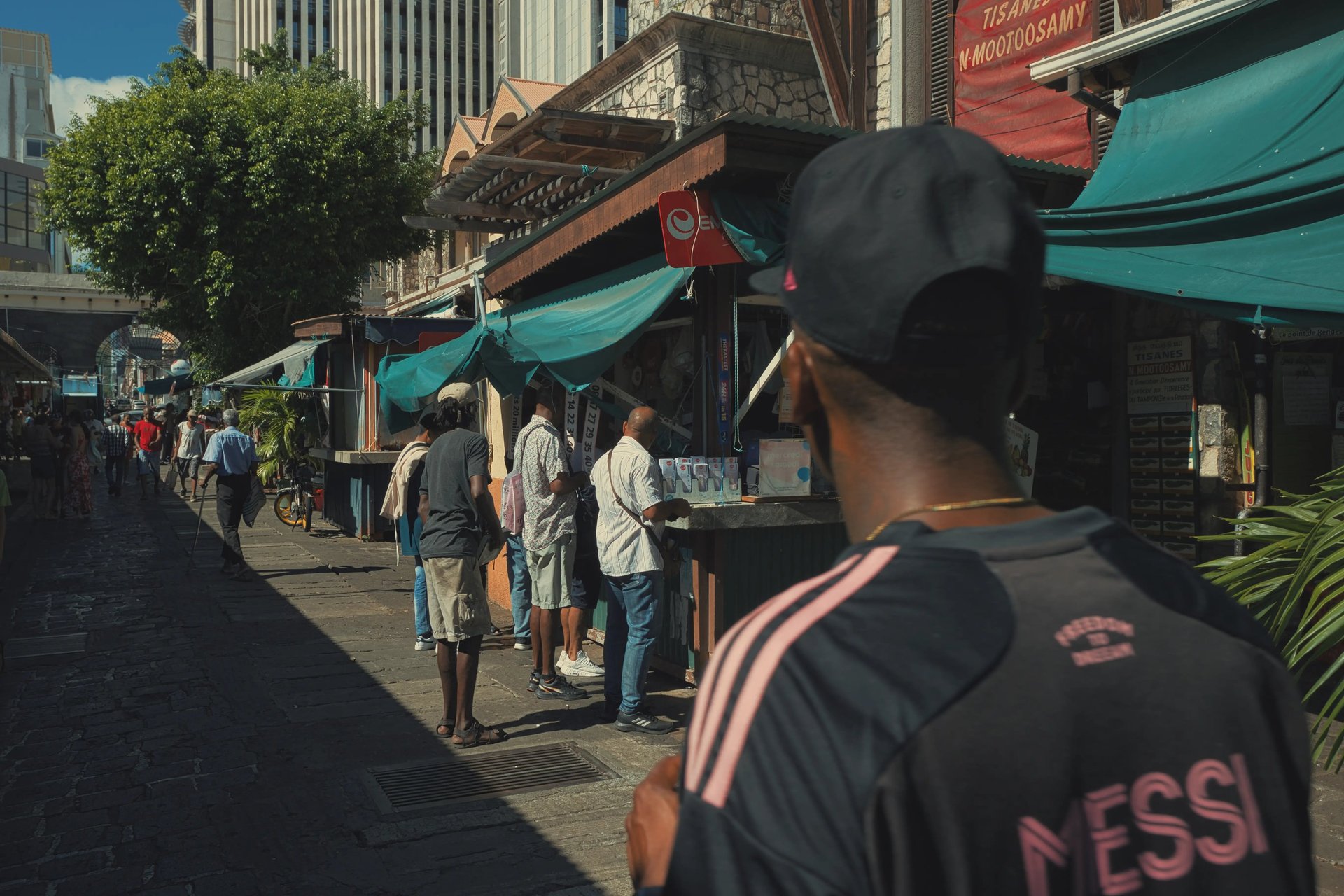 Street photography scene showing daily life outside food stalls at the Central Market in Port Louis, Mauritius