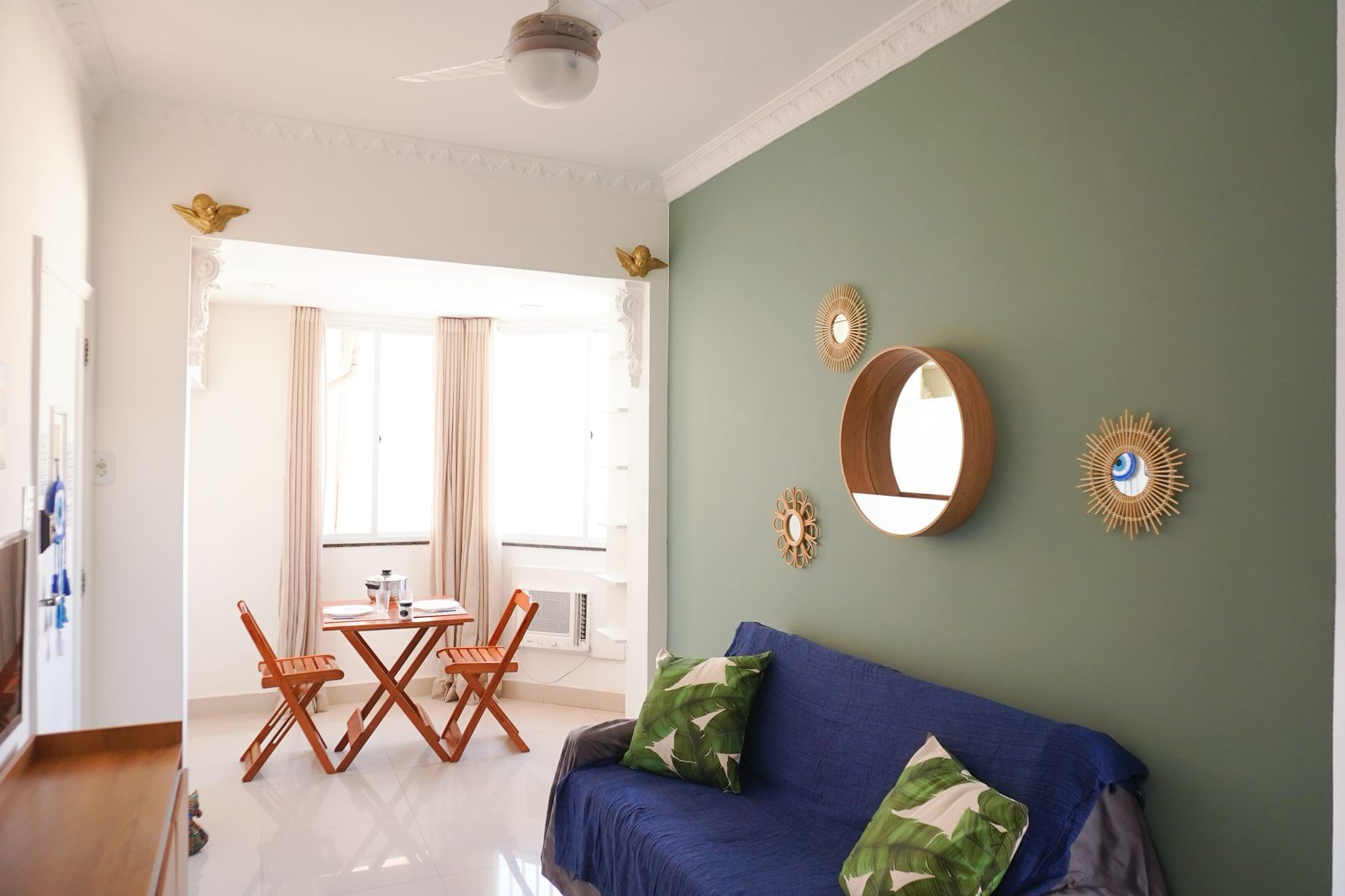 a couch with pillows and a table with chairs