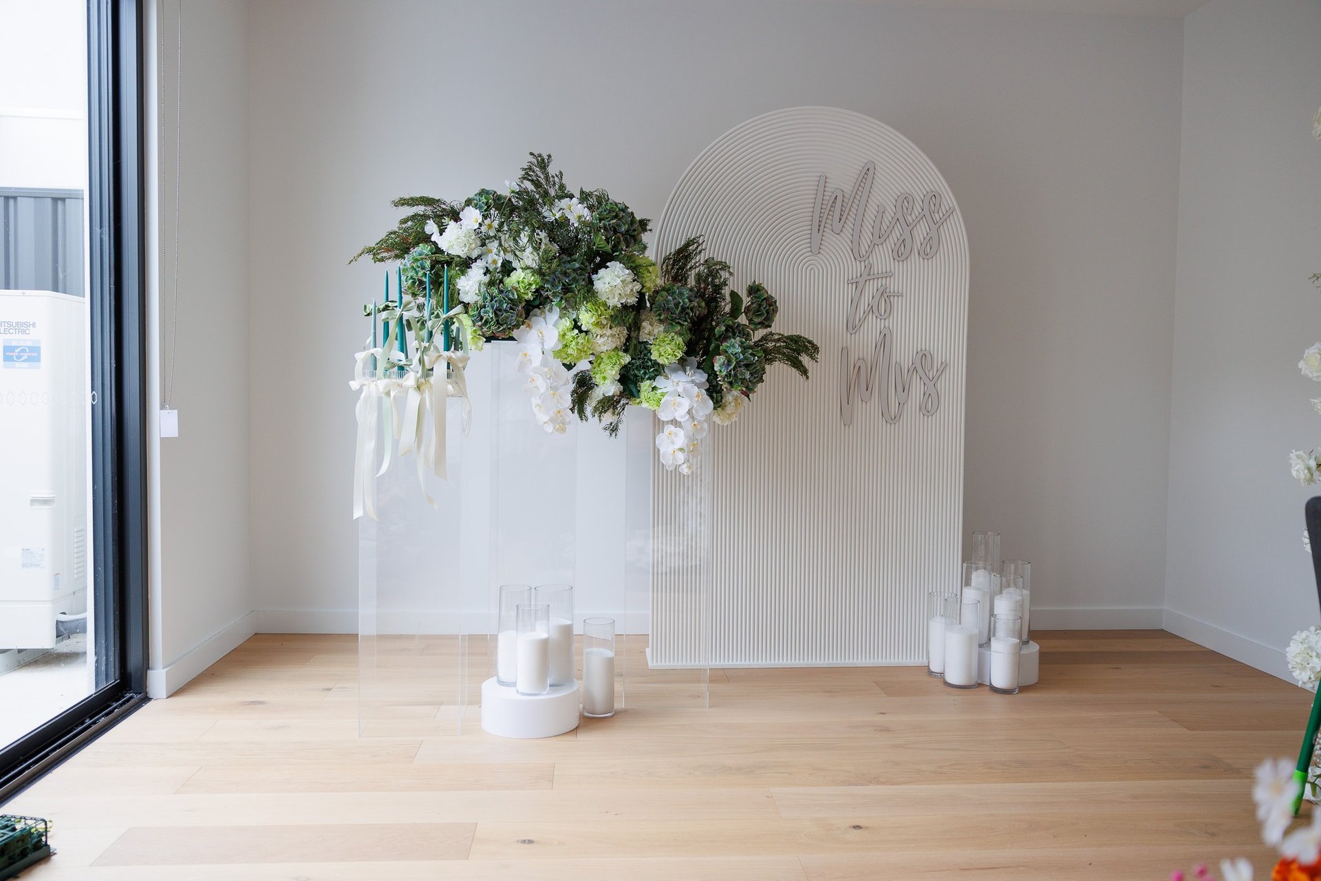 a vase with flowers and candles on a wooden floor