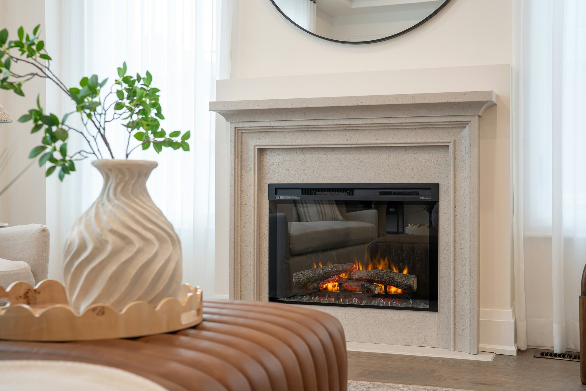 luxury white stone fireplace with leather ottoman in foreground