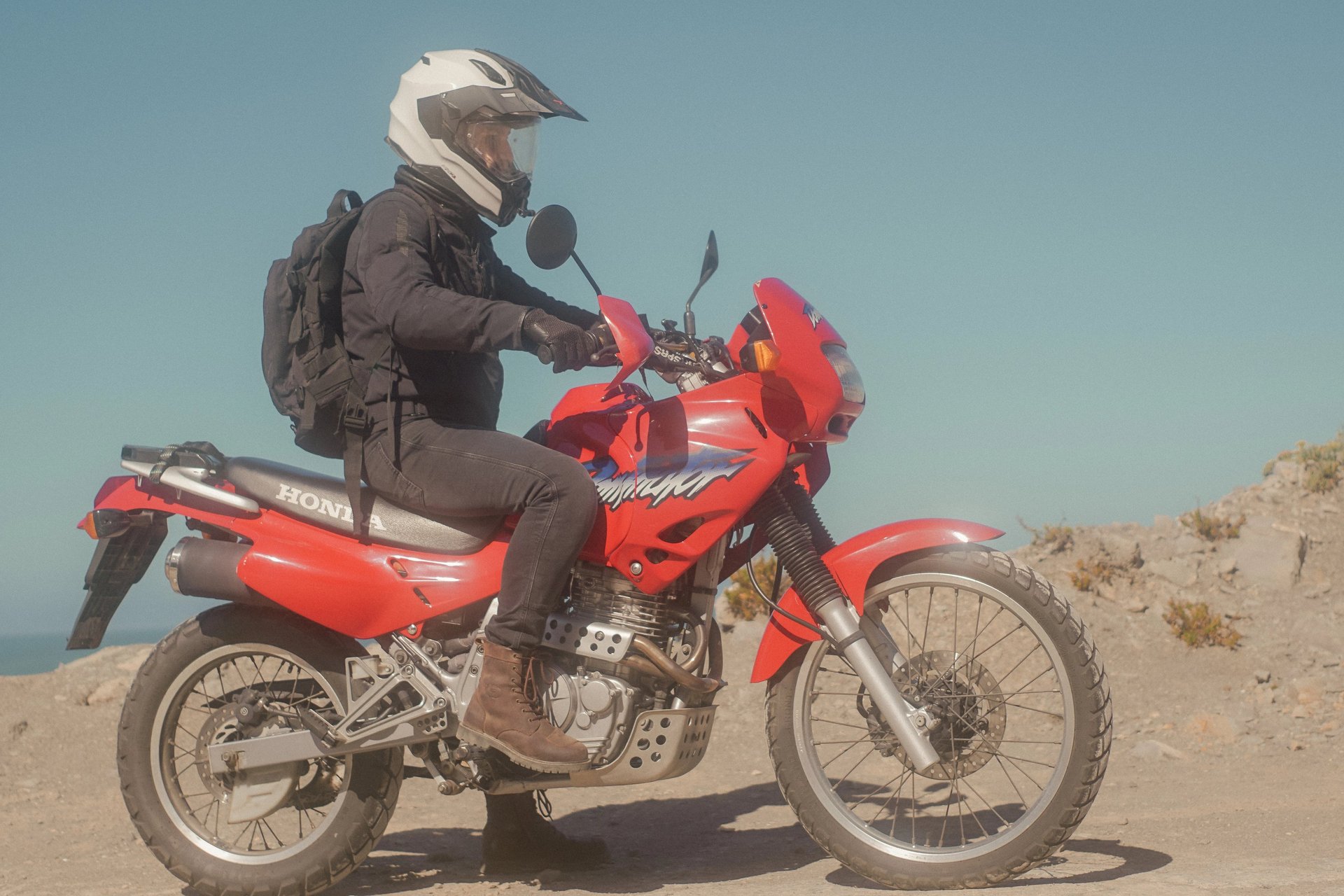man sitting on his motorcycle in the desert