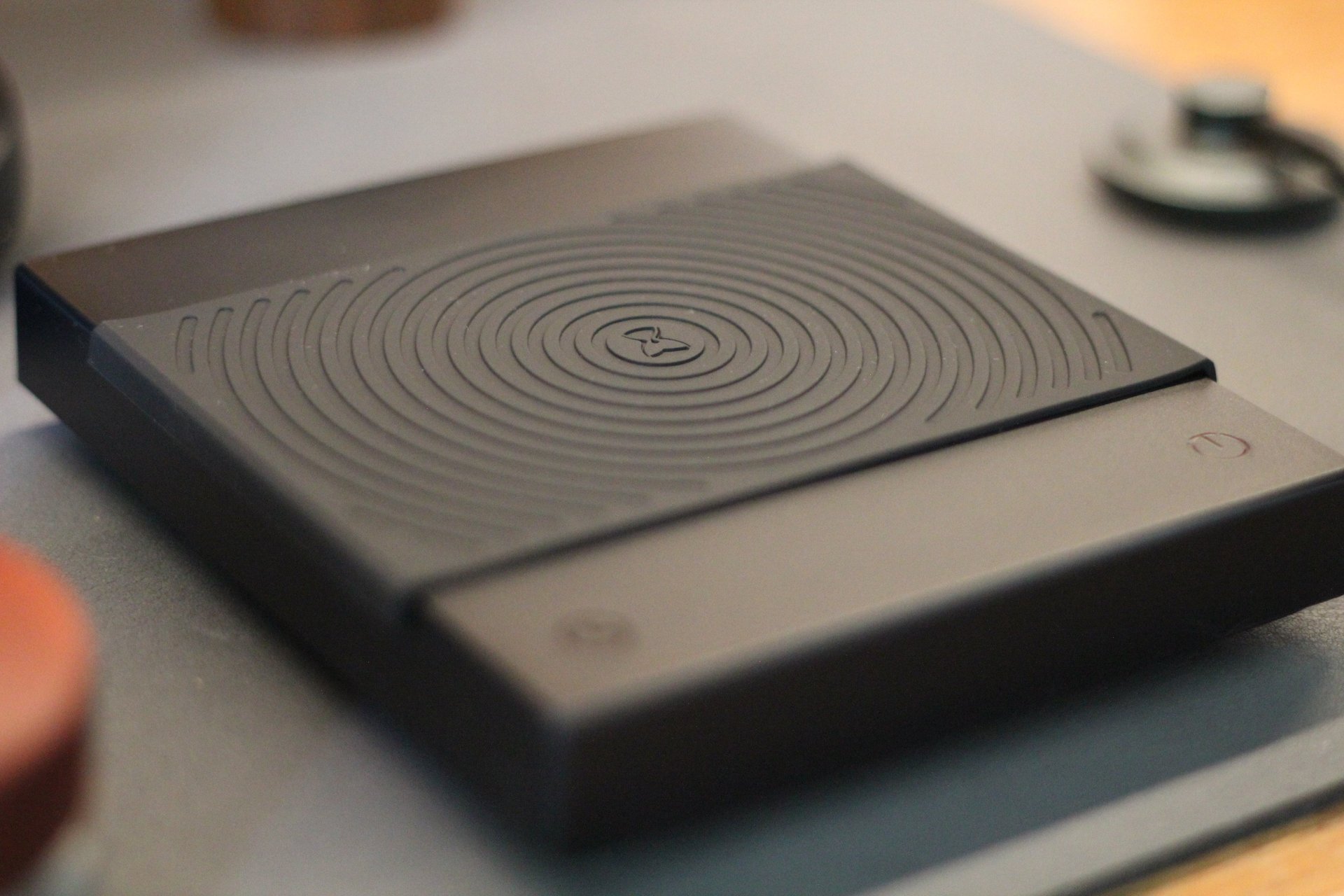 A black TIMEMORE coffee scale with a grooved rubber heat resistant mat for espresso brewing.