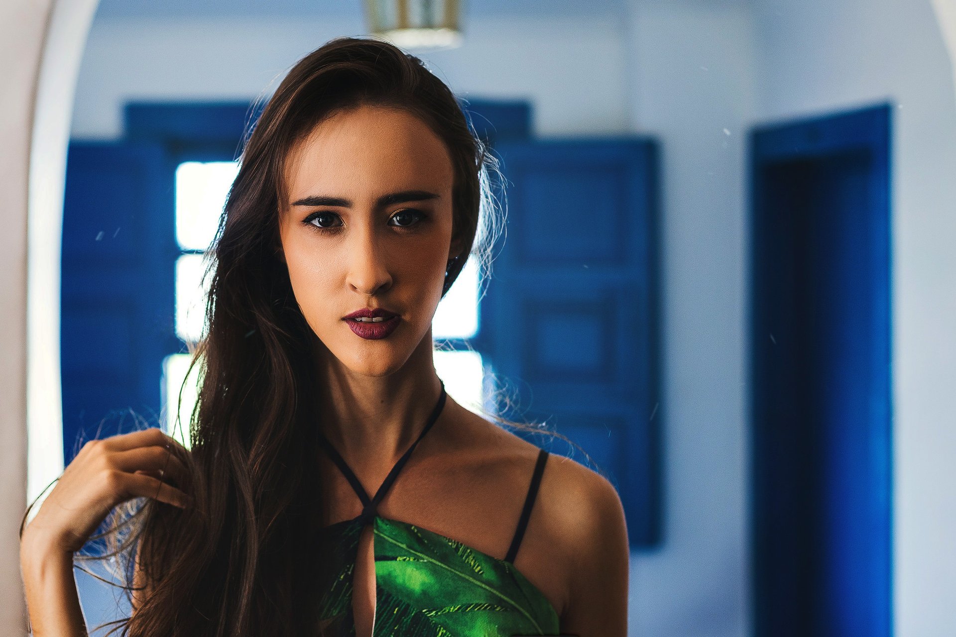 Fashion-inspired portrait of a woman in green with dramatic indoor lighting