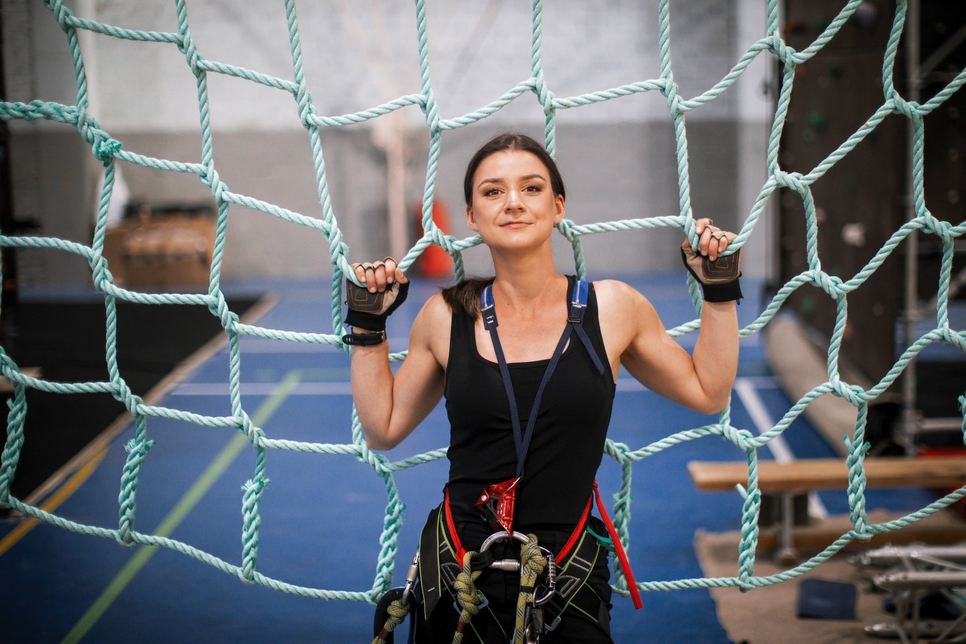 a woman in a black top and climbing harness