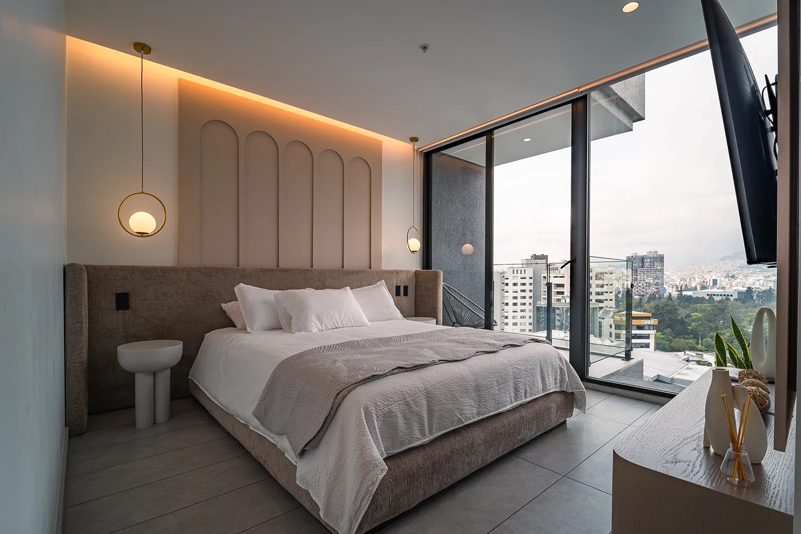Fotografía profesional de AirBnB de lujo en habitación master con lamparas laterales y balcón en Quito