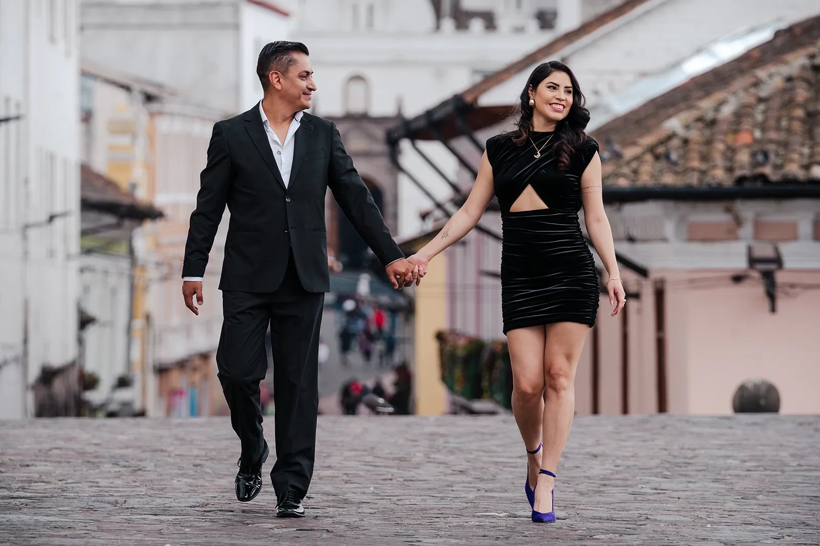 Novios caminando felices y con amor tomados de la mano por el centro histórico de Quito