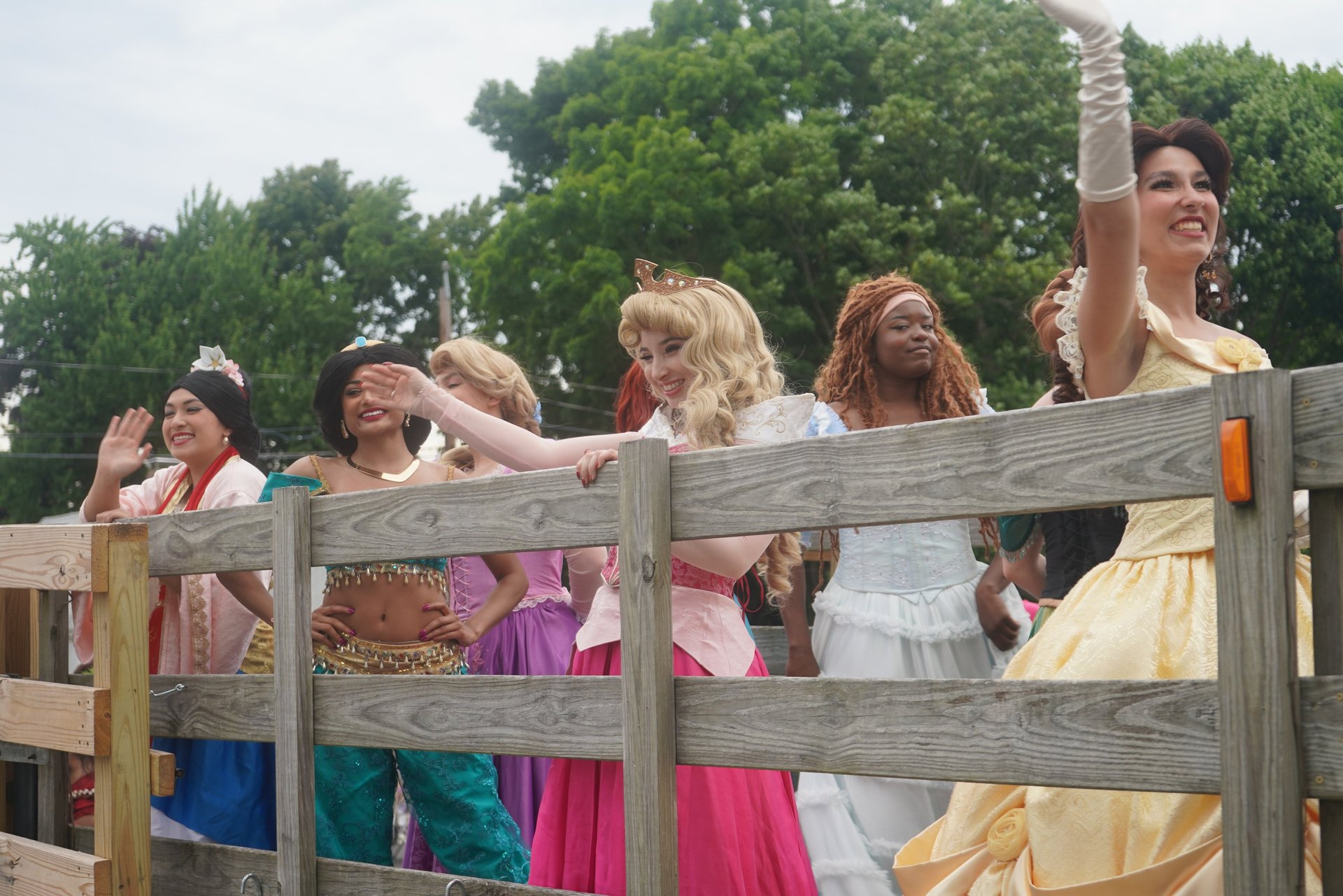 Princesses wave at guests during a parade