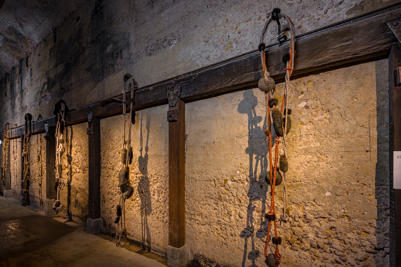 A sculptural installation of woven natural materials suspended inside an industrial site.