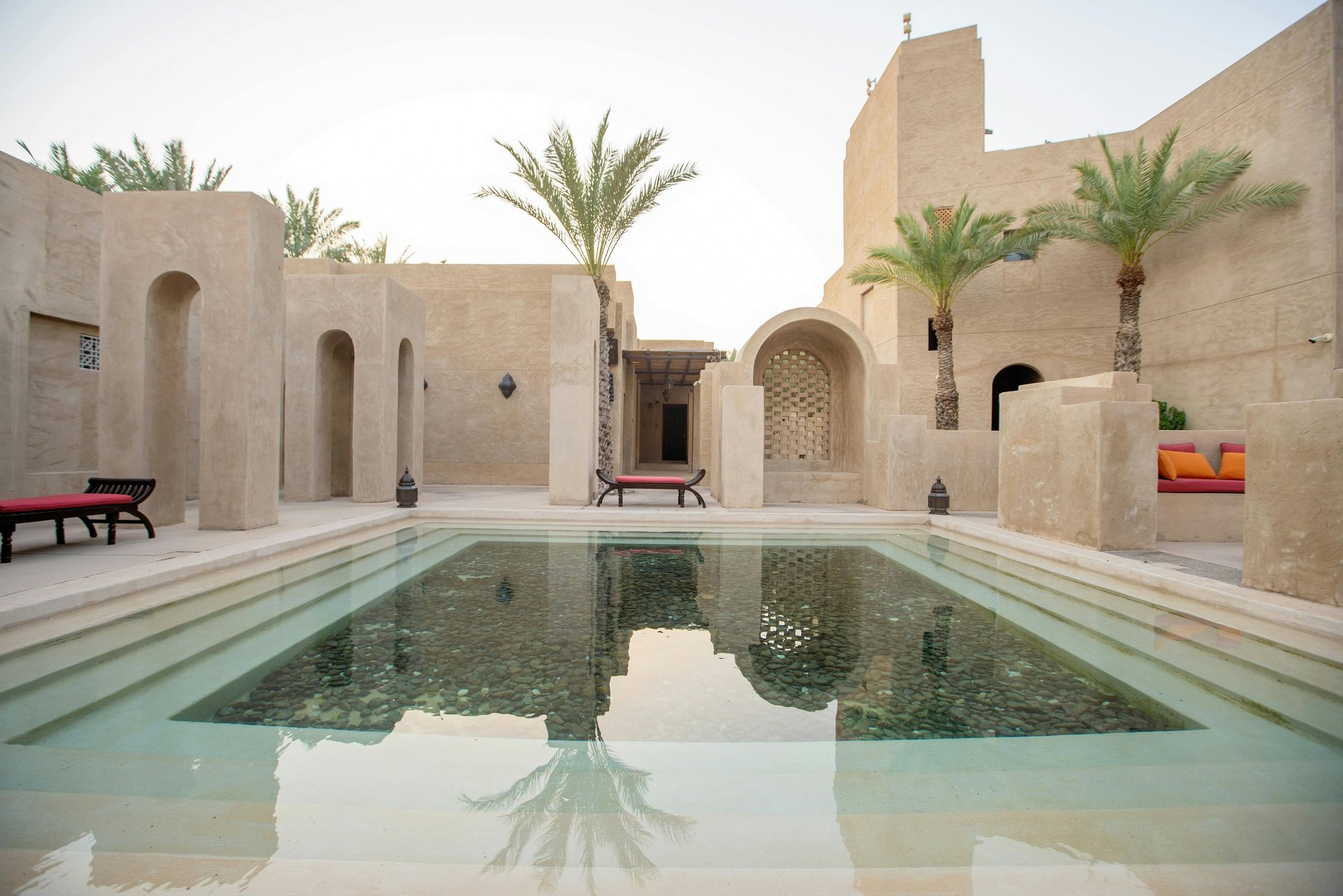 Minimal desert courtyard with reflecting pool and arched architectural walls