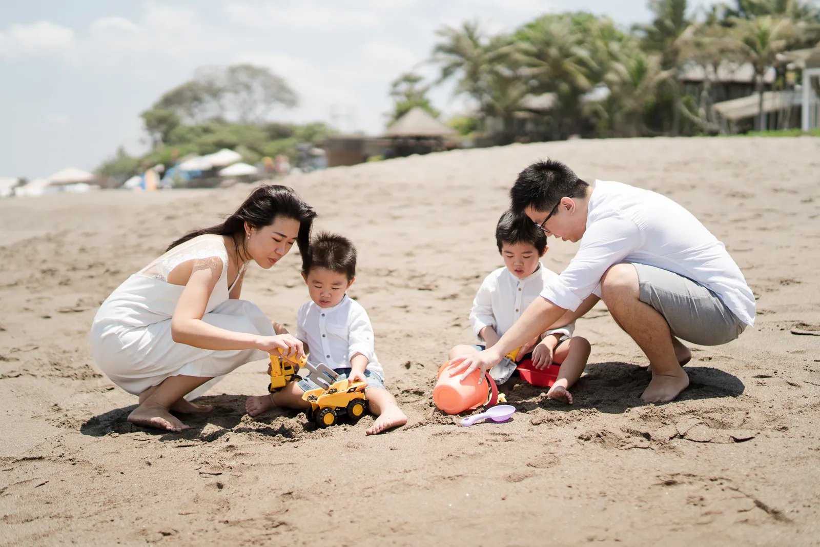 Family playing together on the beach during a natural family photography session in Seminyak Bali