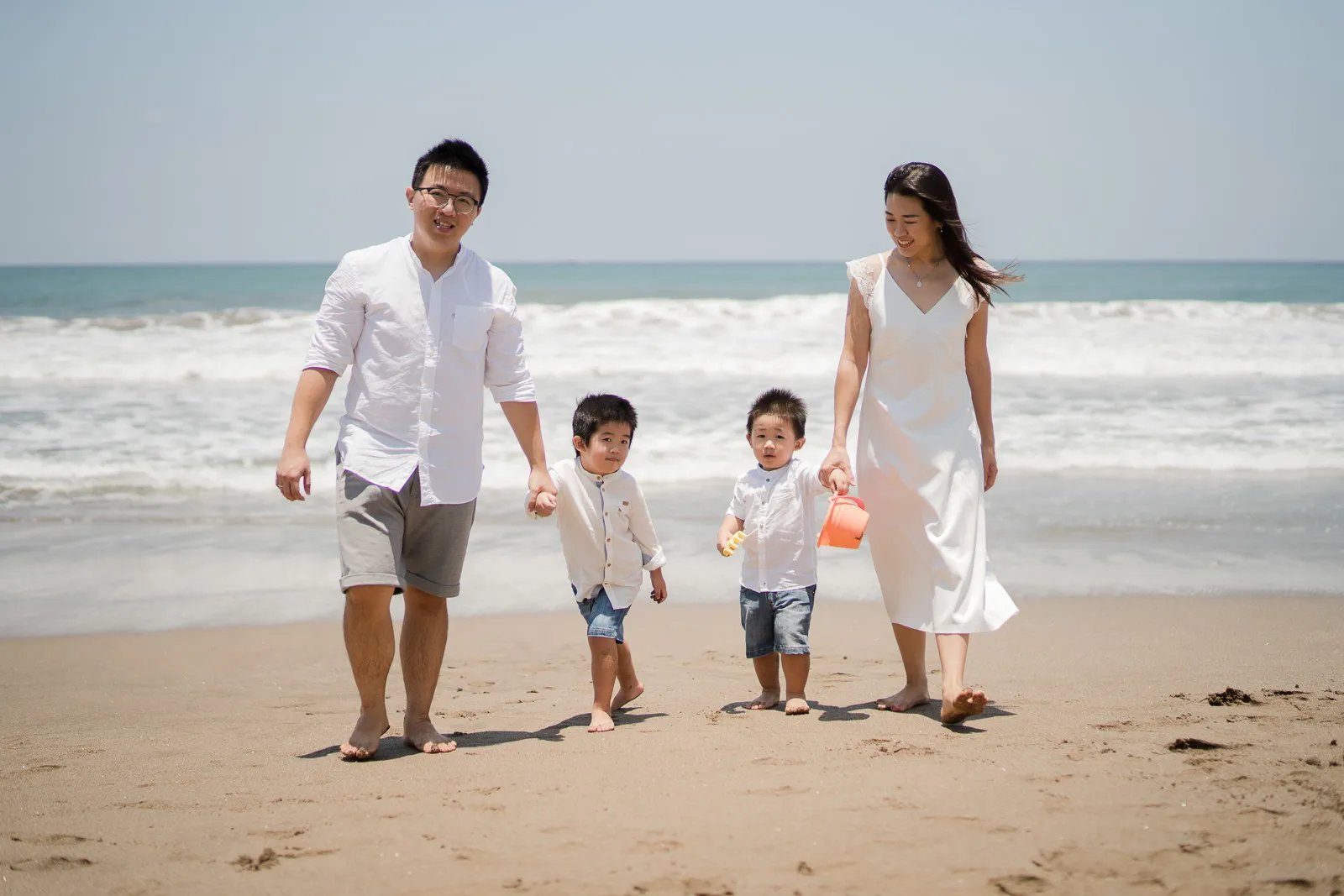 Andi family walking together during a natural beach family session at W Bali Seminyak