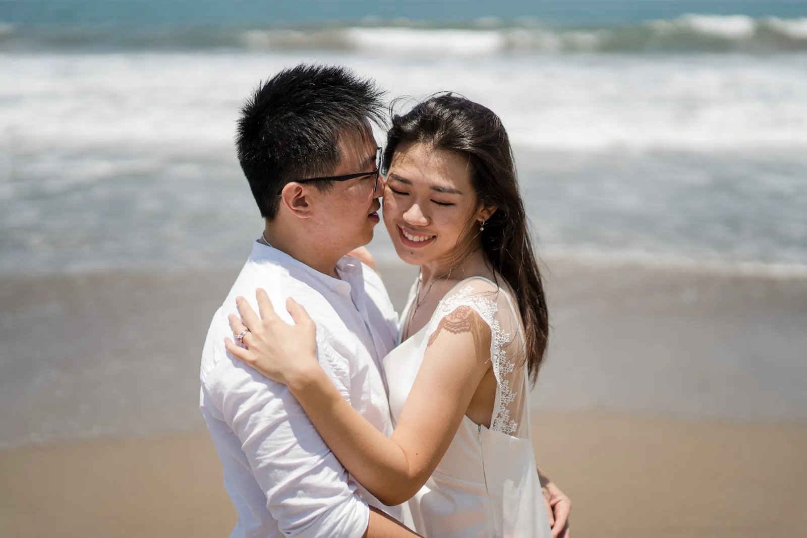 Parents embracing during a calm family photography session at Seminyak Beach Bali