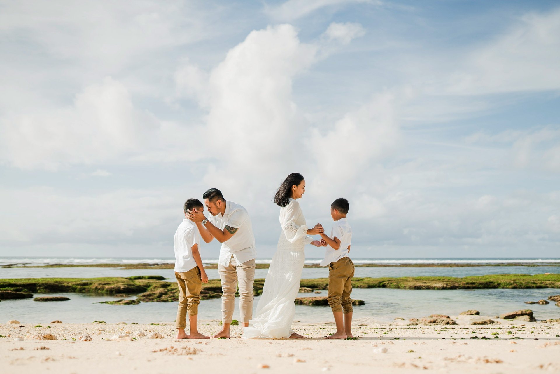 Family beach photography at Melasti Beach Bali, relaxed cinematic family session