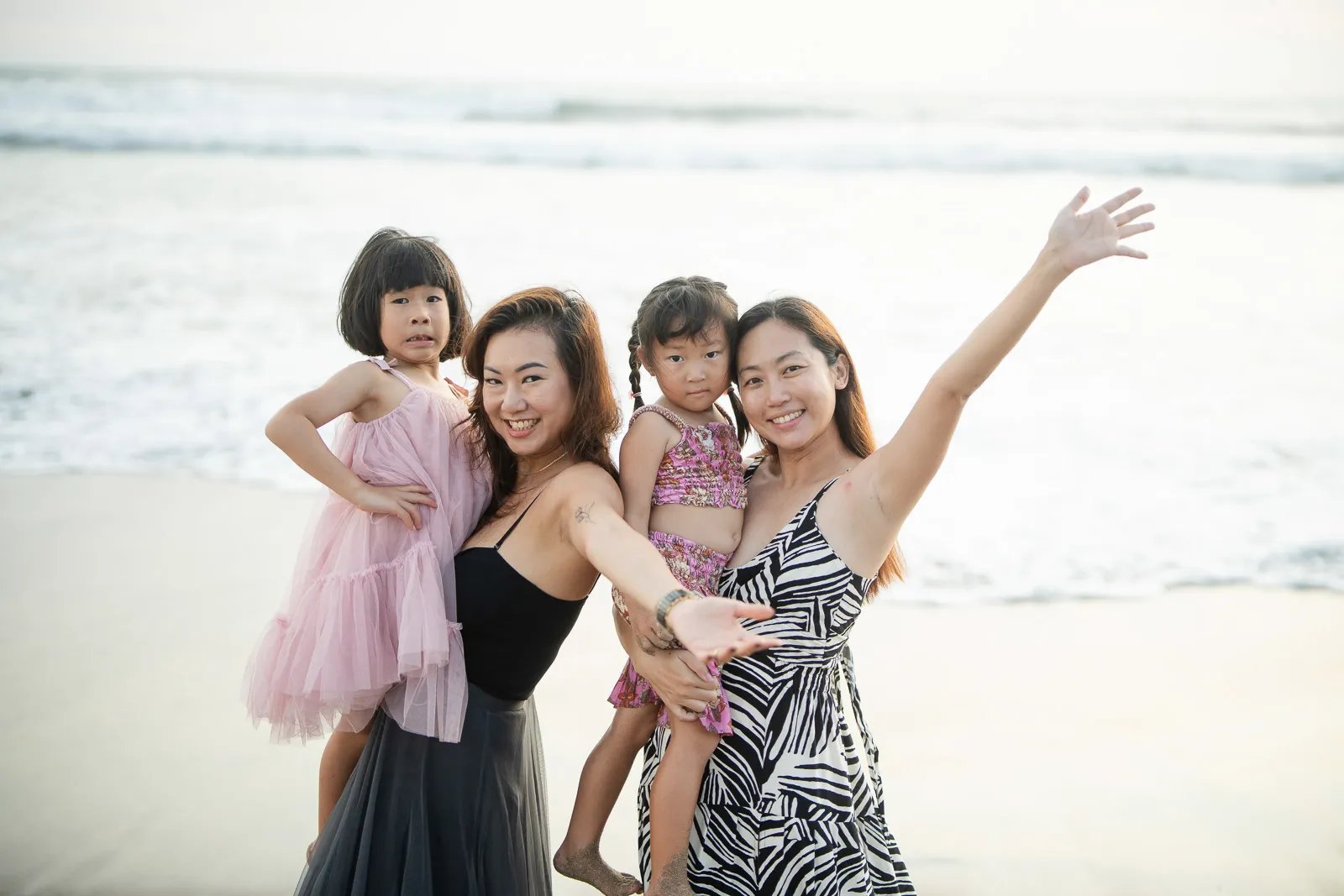 Two mothers and children during joyful family photography session at Padma Resort Legian Bali by the beach.