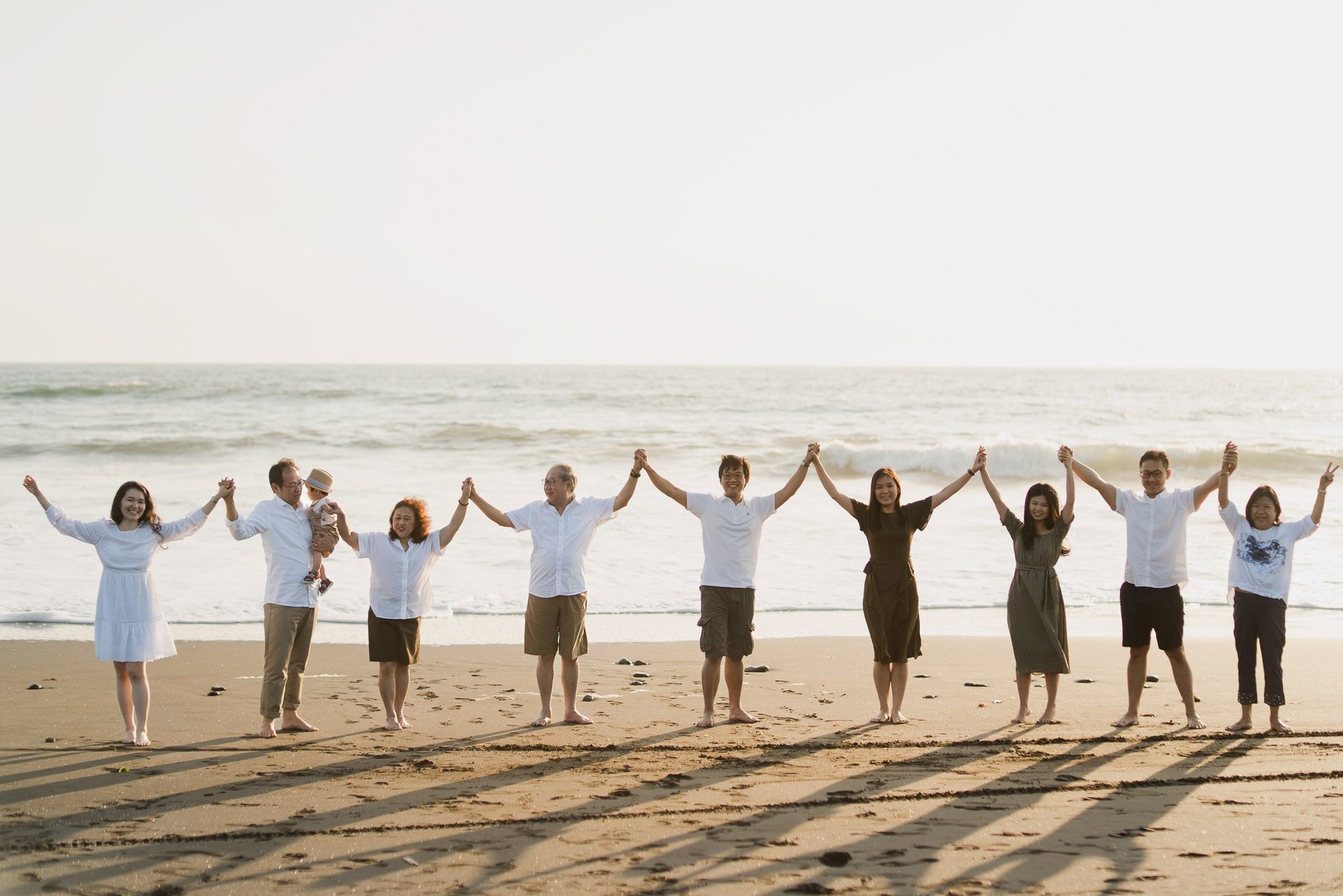 Large multi generation family standing together on Nyanyi Beach in Tabanan Bali during a sunset family photography session