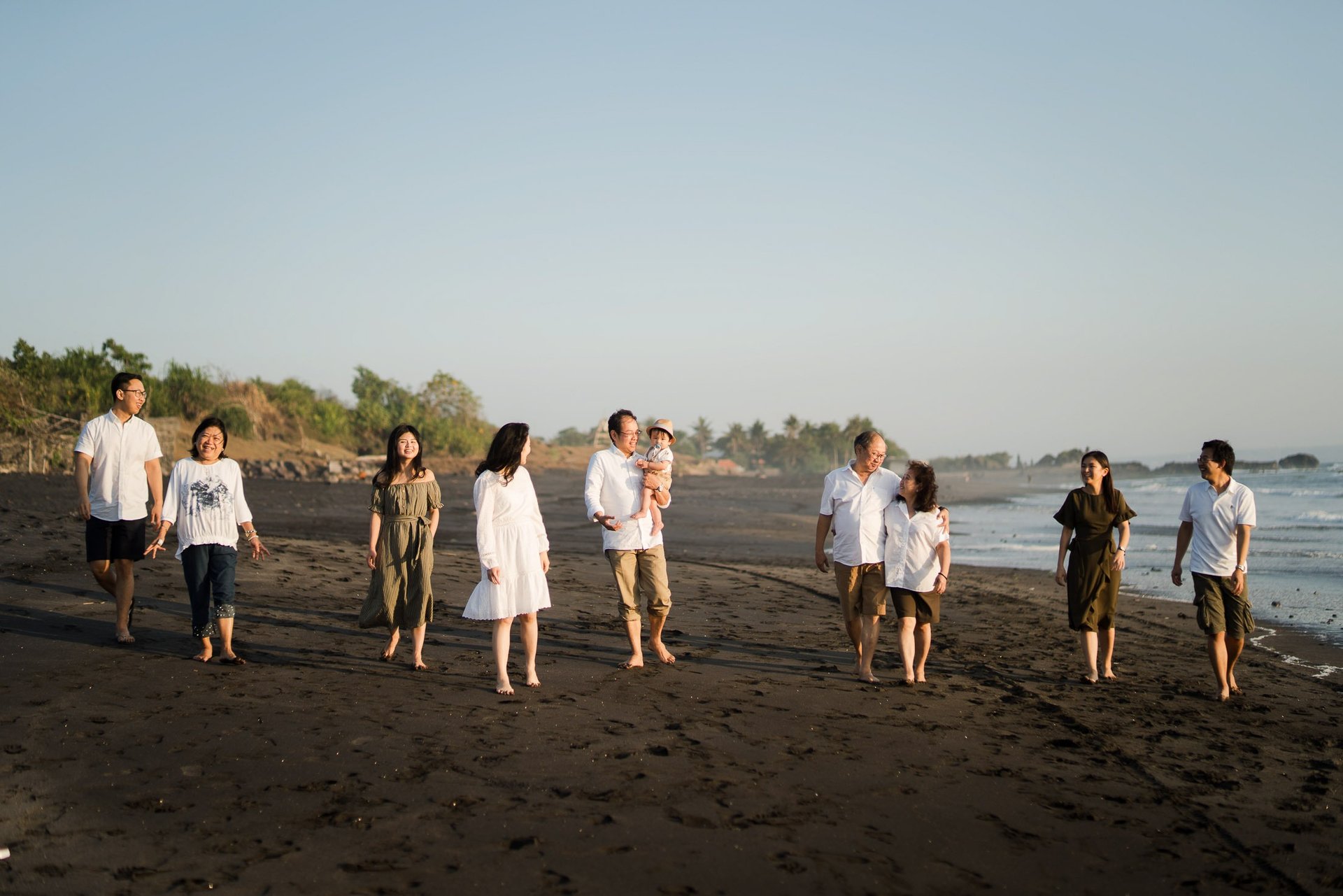 Family walking together along the shoreline of Nyanyi Beach Bali during a relaxed holiday family photography session