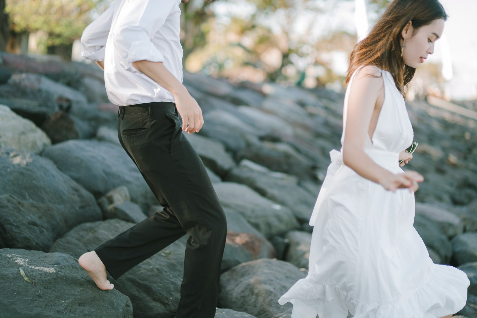 Couple walking on rocks during an intimate photography session at Novotel Bali Benoa in Tanjung Benoa Bali.