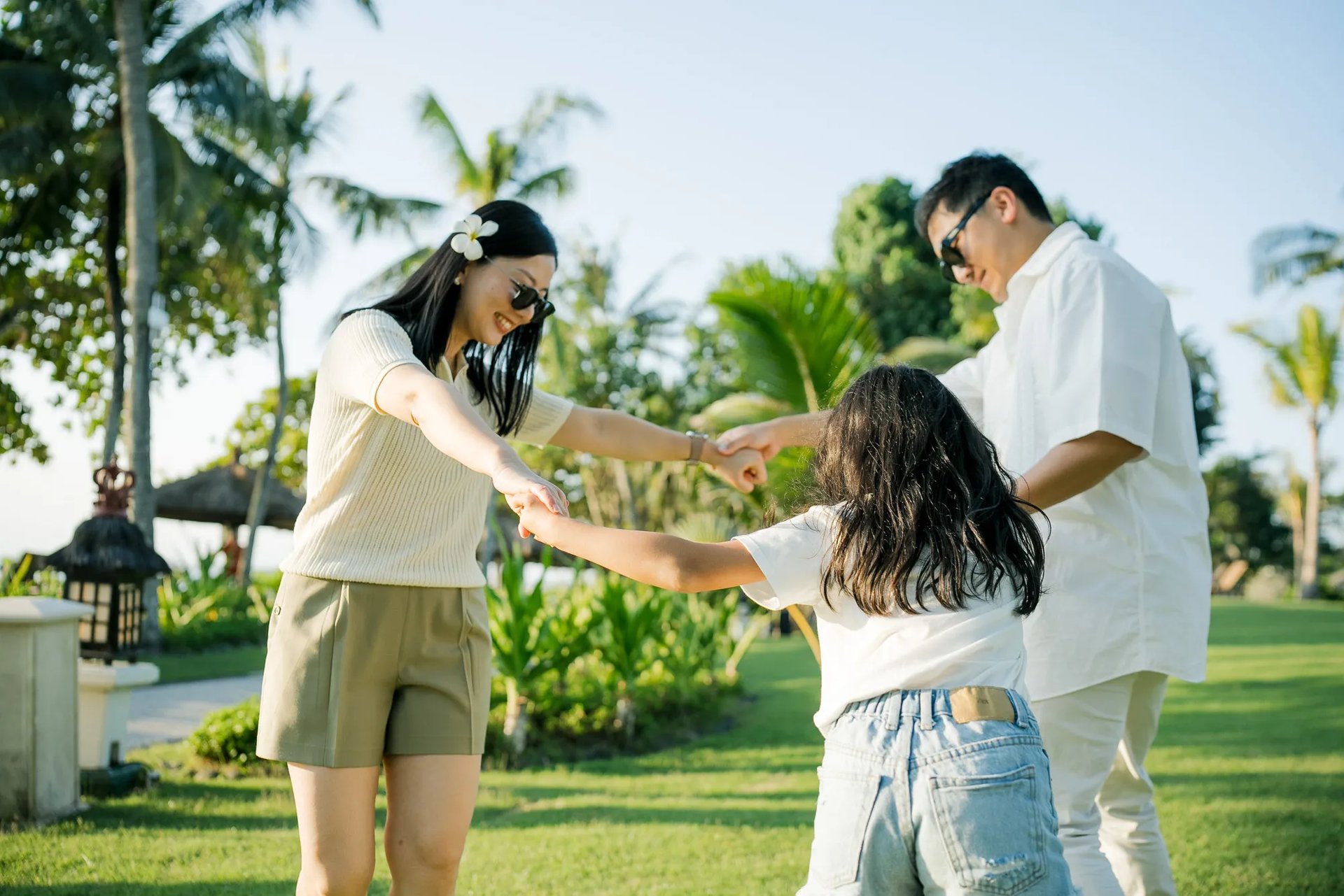 Family playing together on the lawn during a family photography session at InterContinental Bali Resort